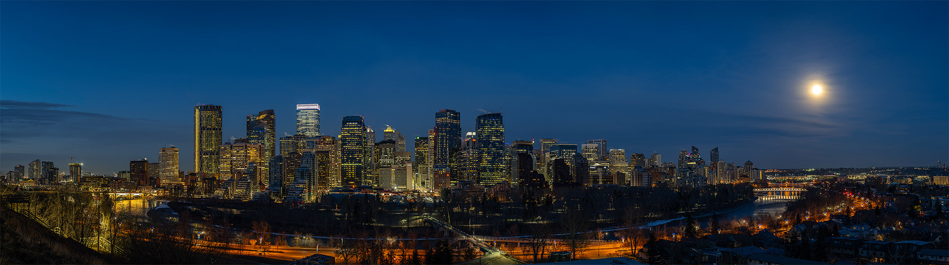 Panoramic Cityscape (9 shot) of the downtown skyline, setting Moon (Waning Gibbous, 99.2%), Bow River, Peace Bridge, Centre St. Bridge, Memorial Dr., [pre sunrise, Nautical Twilight (sun altitude -7.6 degrees)], from Crescent Heights Lookout Point, Calgary, AB