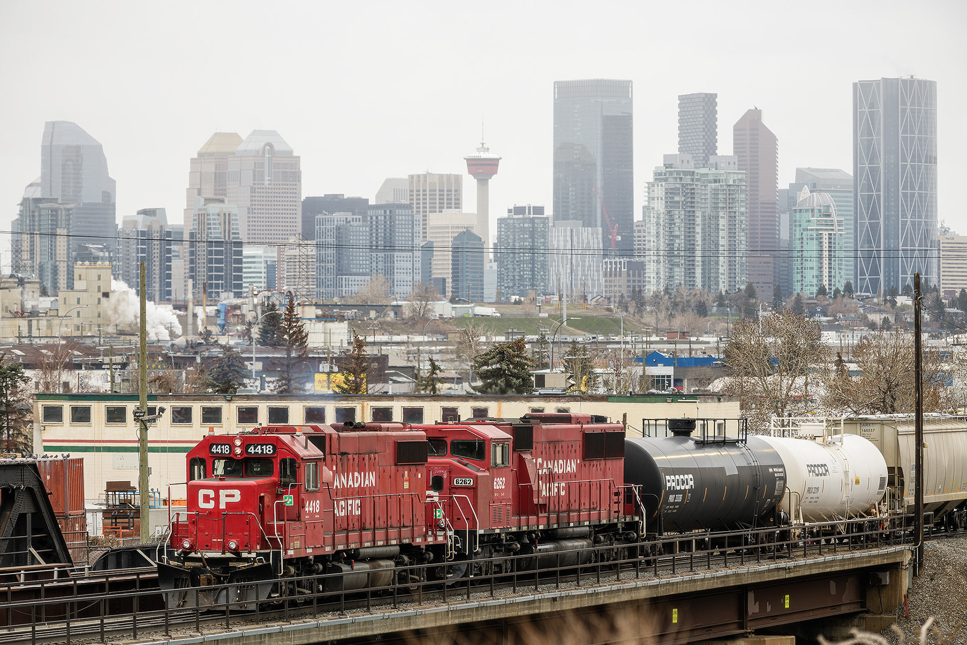 Photo of a train locomotive, with the Downtown Calgary skyline in the background, from near Southview Off Leash Dog Park, Calgary, AB - April 26th