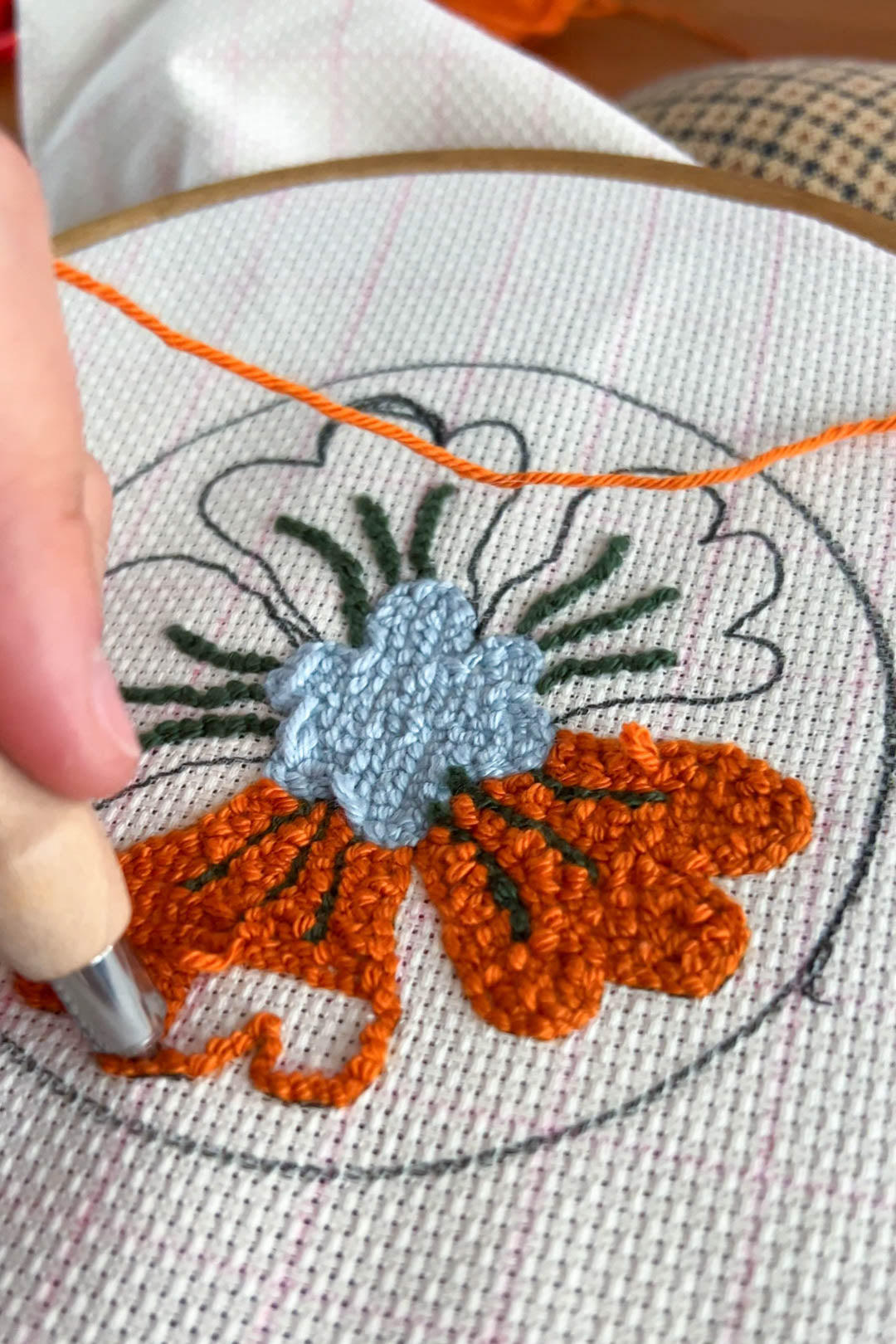 process photo of punch needle coaster with flower illustration. By Bianca Gschlecht