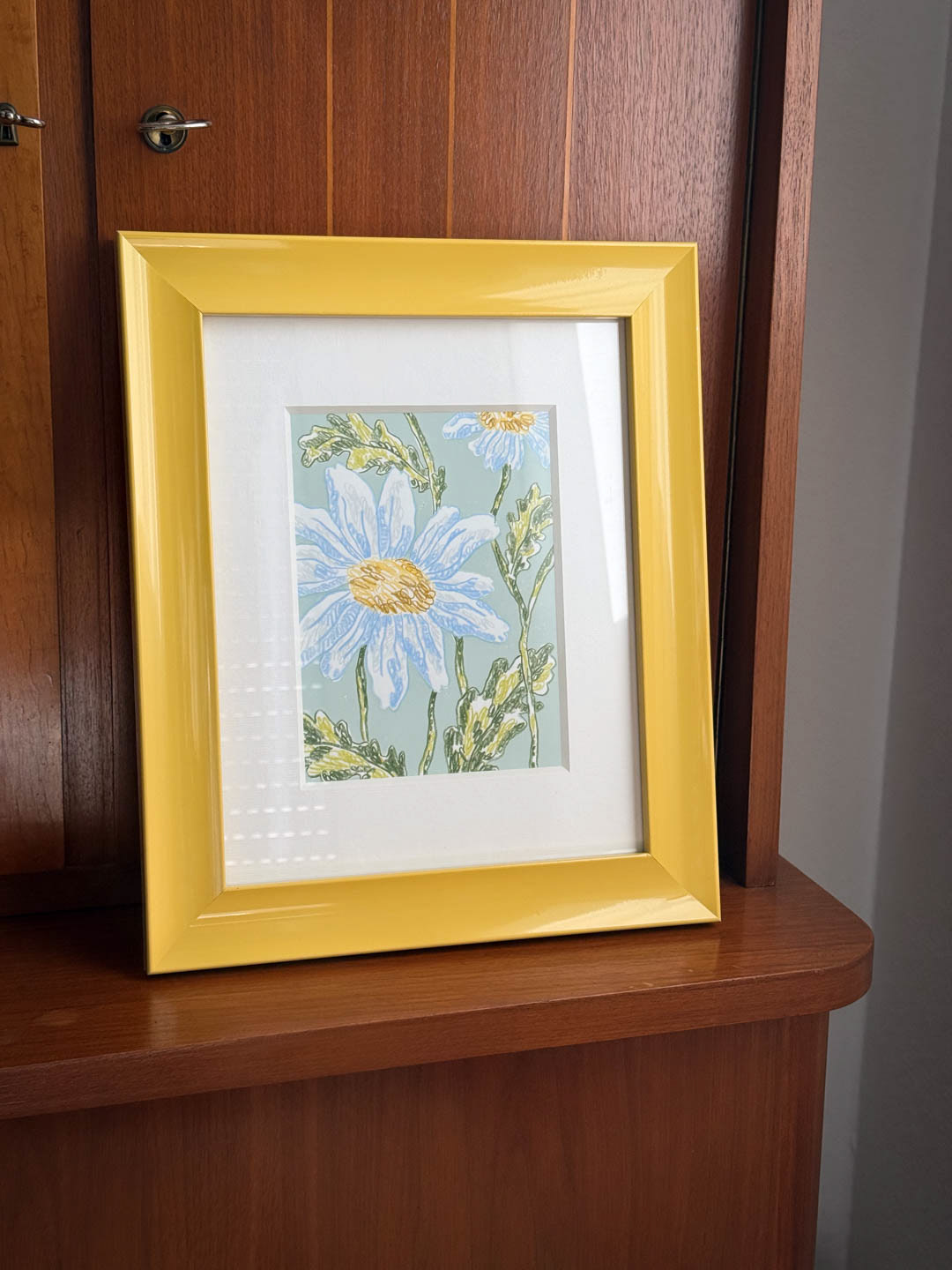 Photo of a framed, hand-made daises print by Bianca Gschlecht