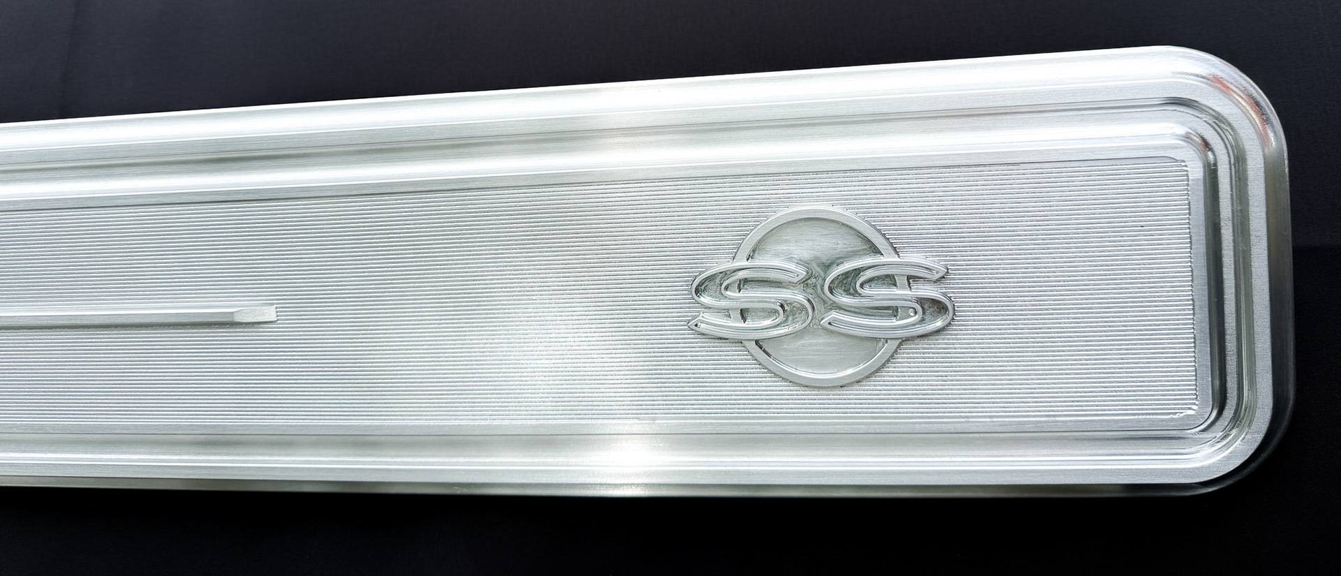Passenger side detail of 1966 Nova SS trunk emblem molding with SS badge area