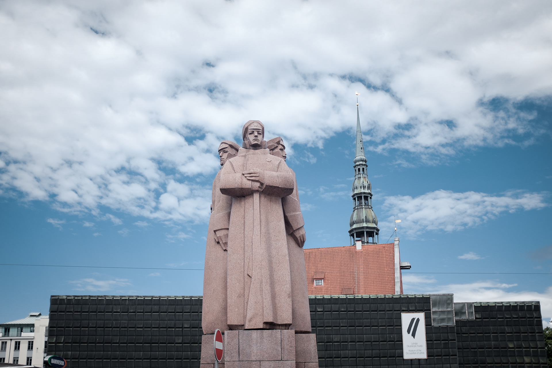 Pomník lotyšských střelců - kontroverzní socha věnovaná památce lotyšských Rudých střelců, kteří sloužili v Leninově osobní gardě. V pozadí bývalý sovětský bunkr, jedna z mála ponechaných ošklivých sovětských staveb