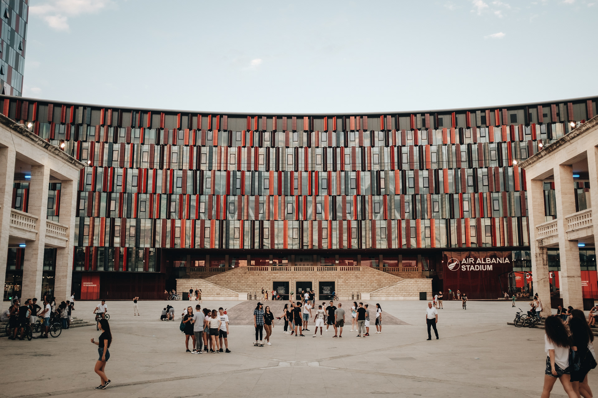 Tiranský stadion a před ním spot pro mlaďasy