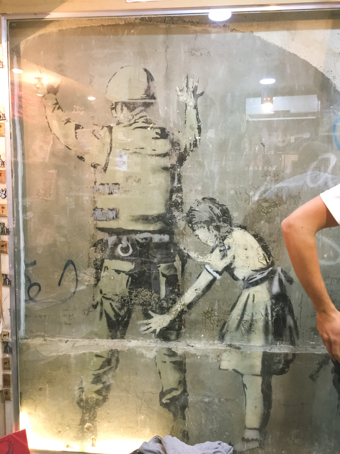 Banksy (za plexisklem v obchodě, kterej vzniknul kolem graffiti)