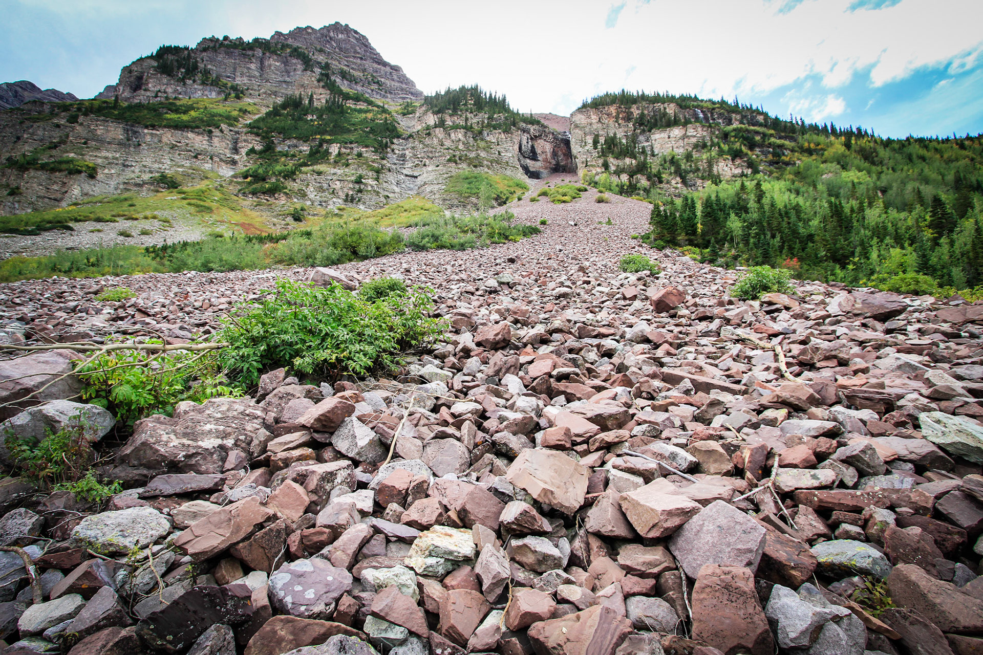Boulder field with a cascading waterfall in the distance