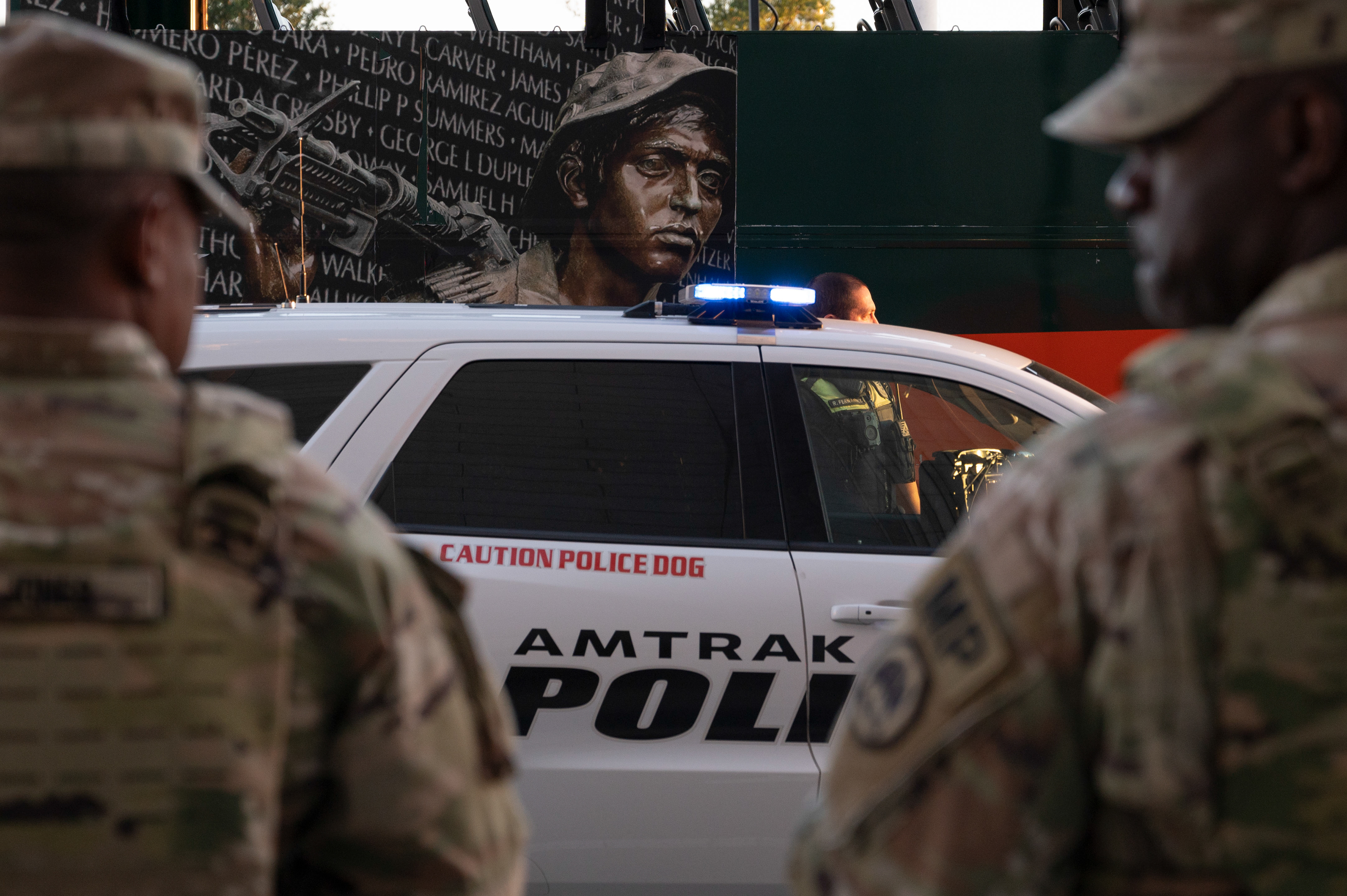 National Guard troops are stationed outside of Union Station on Saturday, August 30, 2025 as a tour bus passes by.