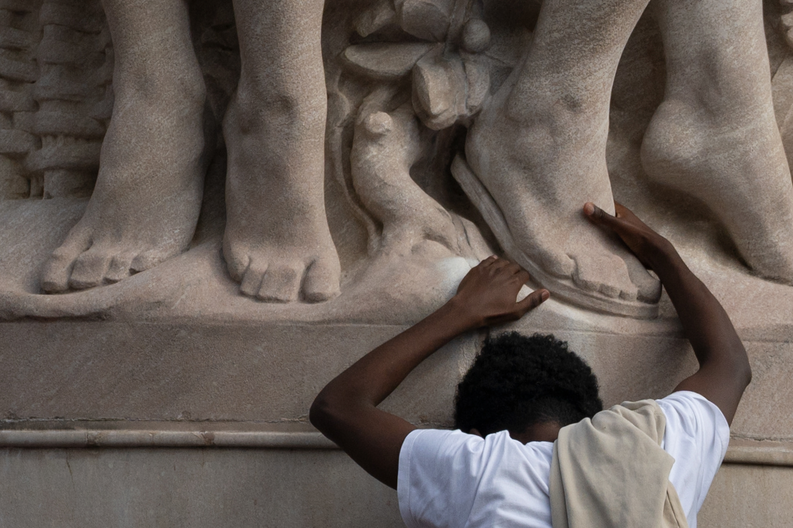 A boy rests against the George Gordon Meade Memorial during the No Kings protest on October 18, 2025.
