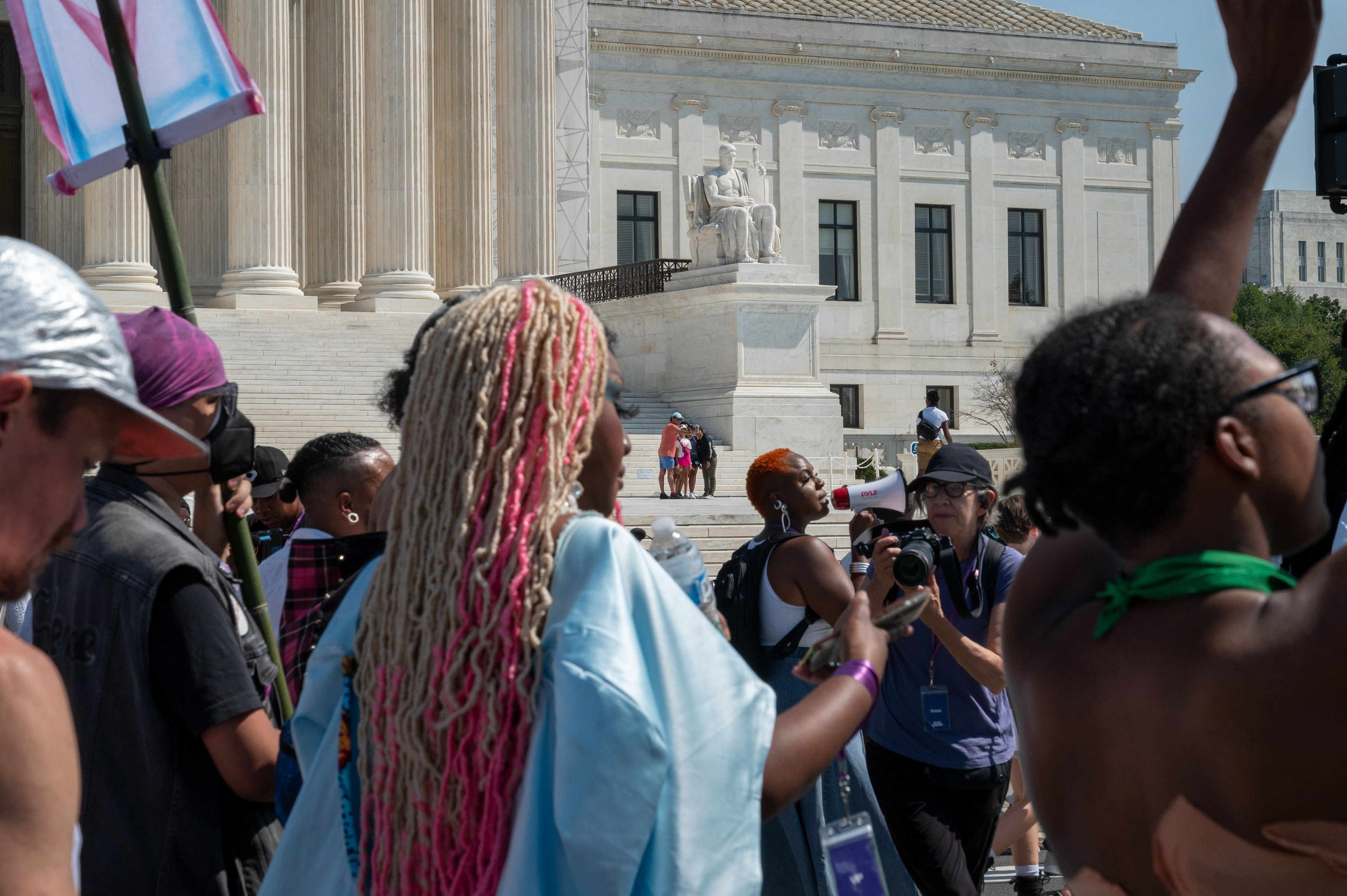 A family takes a photo in front of the Supreme Court as the September 14th Gender Liberation March protests.