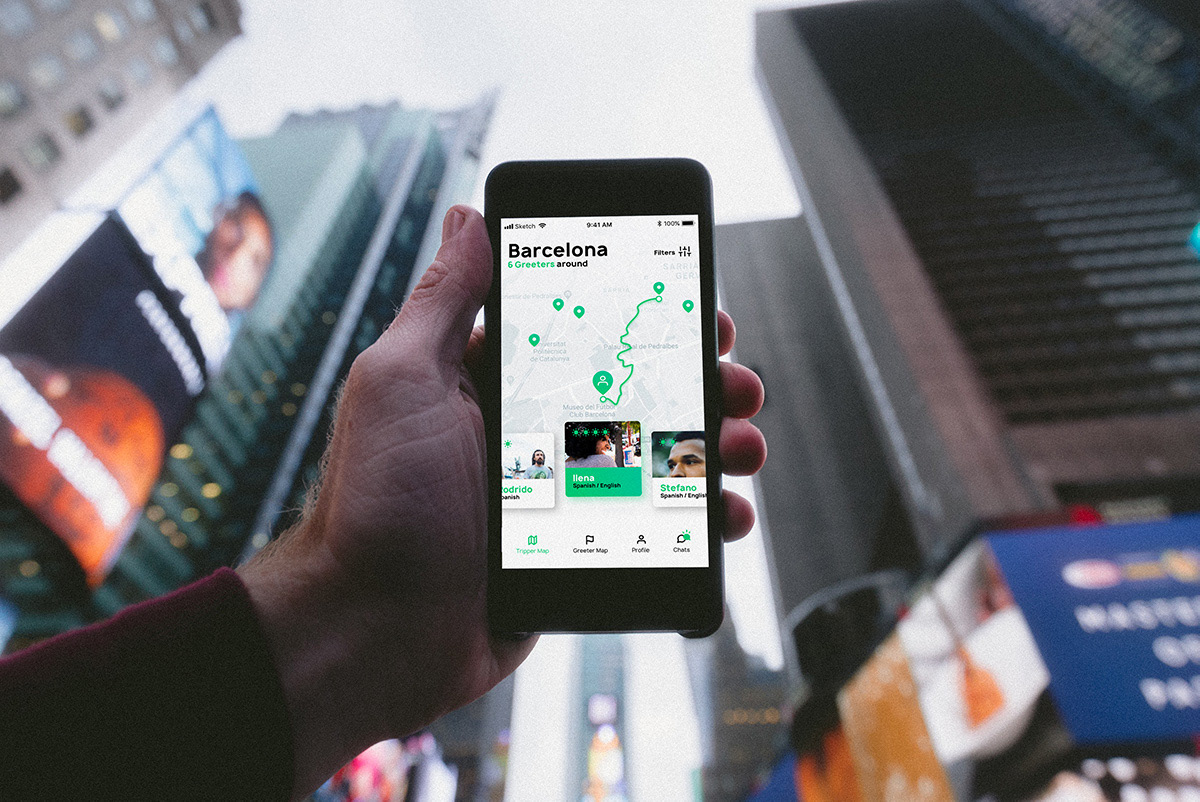 Vue subjective en contre-plongée. Une main tient un smartphone avec l’application ouverte sur une carte de Barcelone.