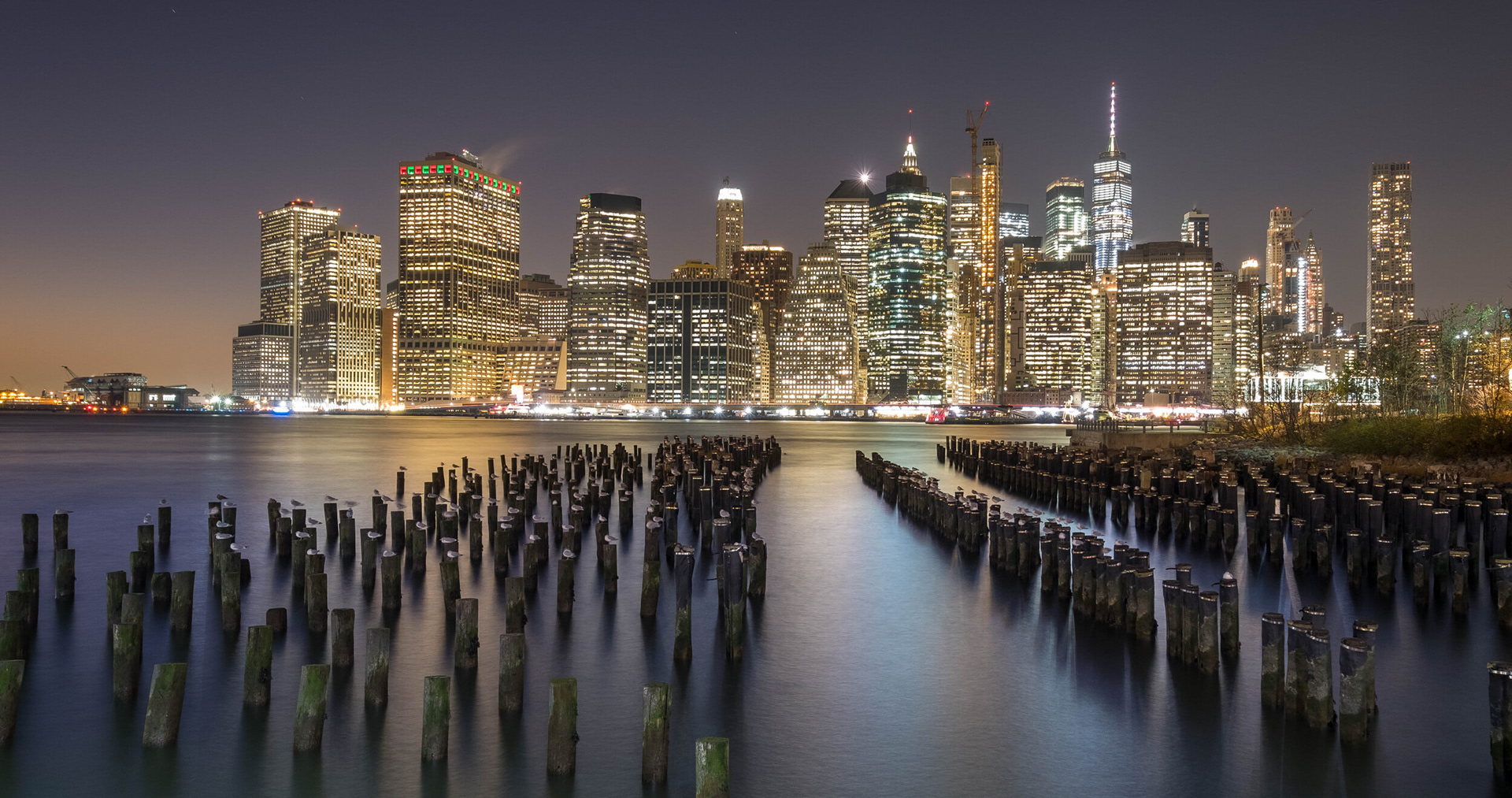 CLASSIC NEWYORKER POSTCARD - After three trips to the "Big Apple", I managed to capture this colorful cityscape on an extremely cold eveniing. I always wanted to take this classic point of view of Manhattan Island from this classic old place: Brooklyn Bridge Park Poles View.   New York City, NY, USA.