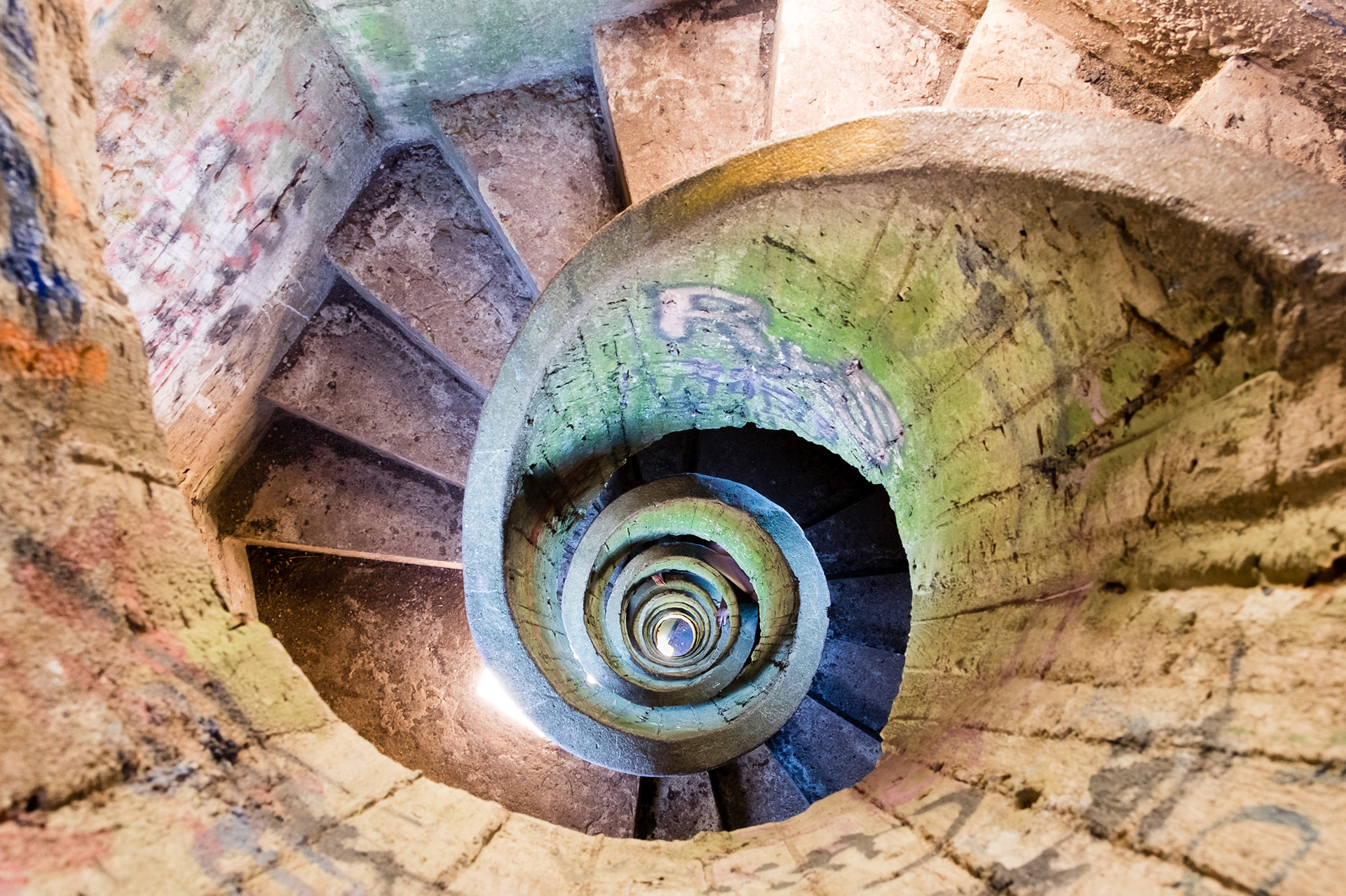 Stairscope - Spiral staircase painted with colorful graffitis inside the big cross, located on top of the Pan de Azucar hill, Maldonado, Uruguay