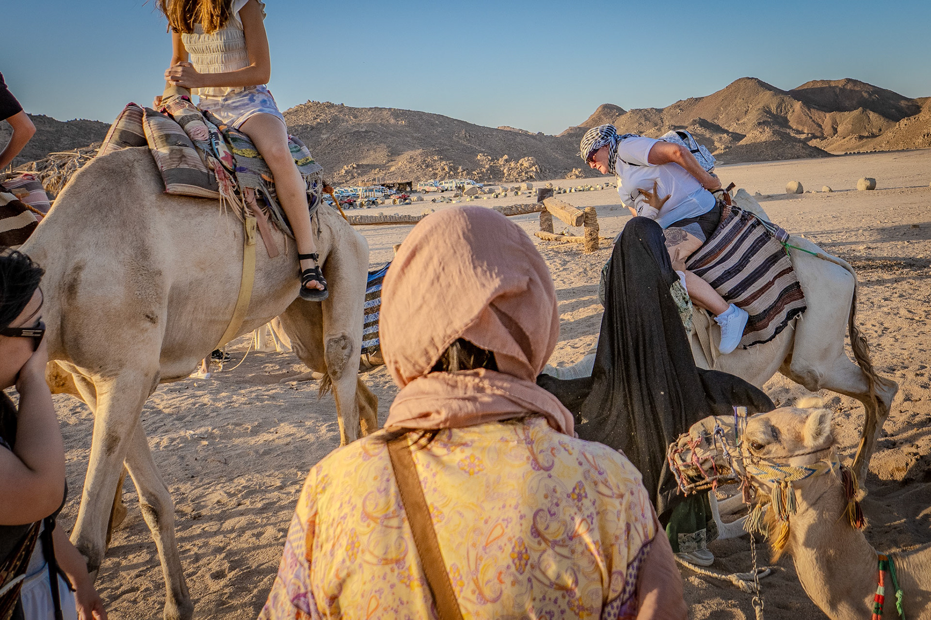 Women dismounting a camel