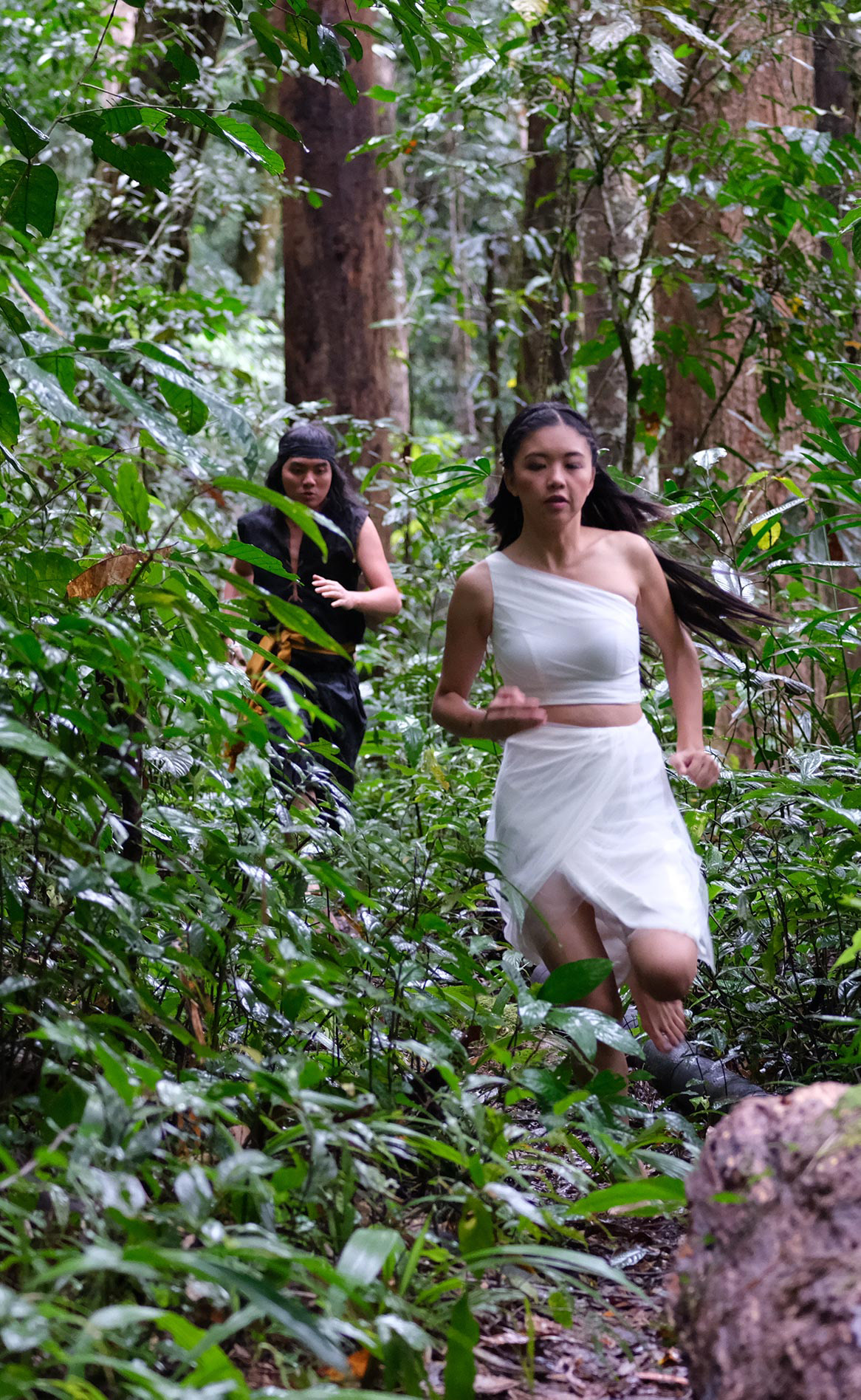 Somboi and Lilip run through the jungle.