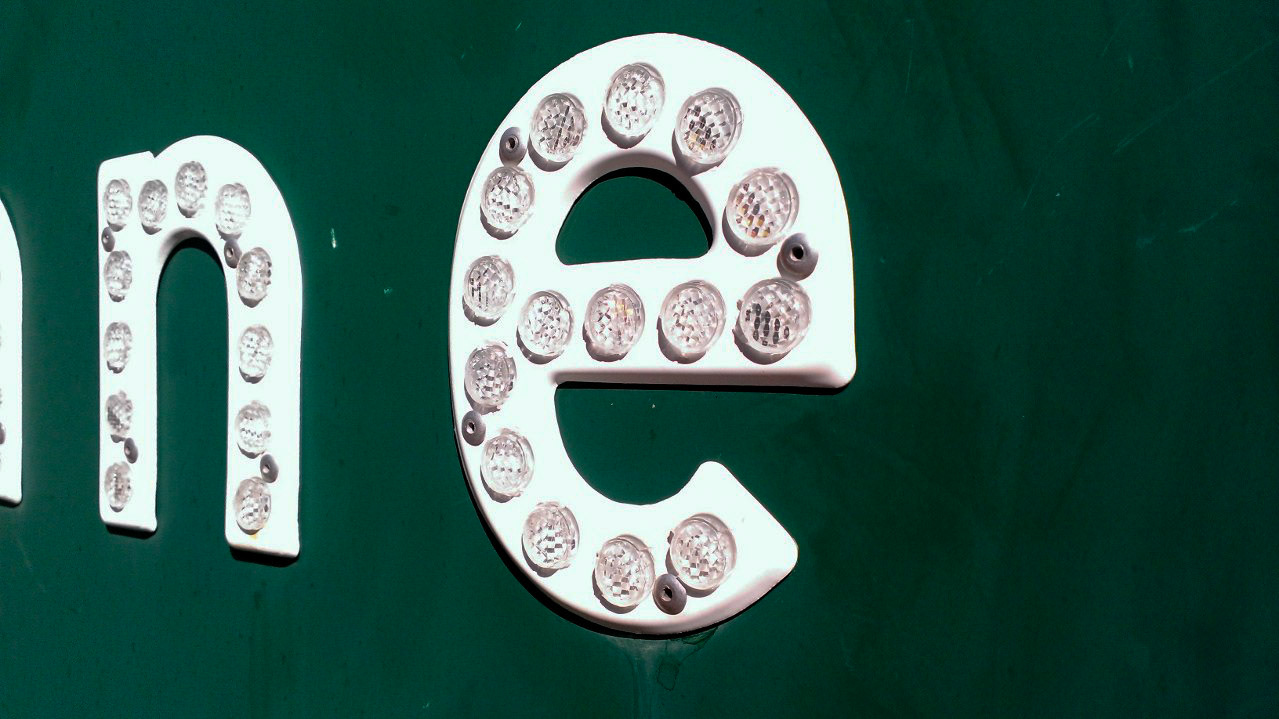 Apparently these crappy signs are white plastic with these reflector bits.