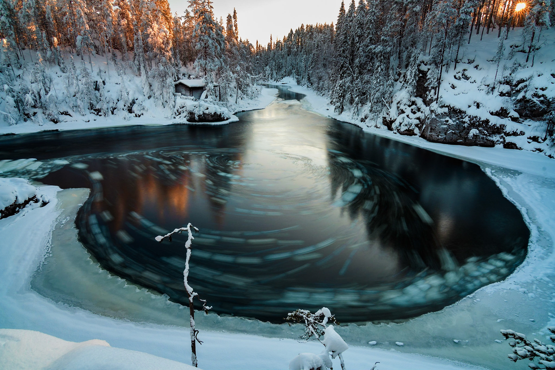 Winter landscape with a river with pieces of drifting ice making circles, Myllykoski, Oulanka National Park, Finland