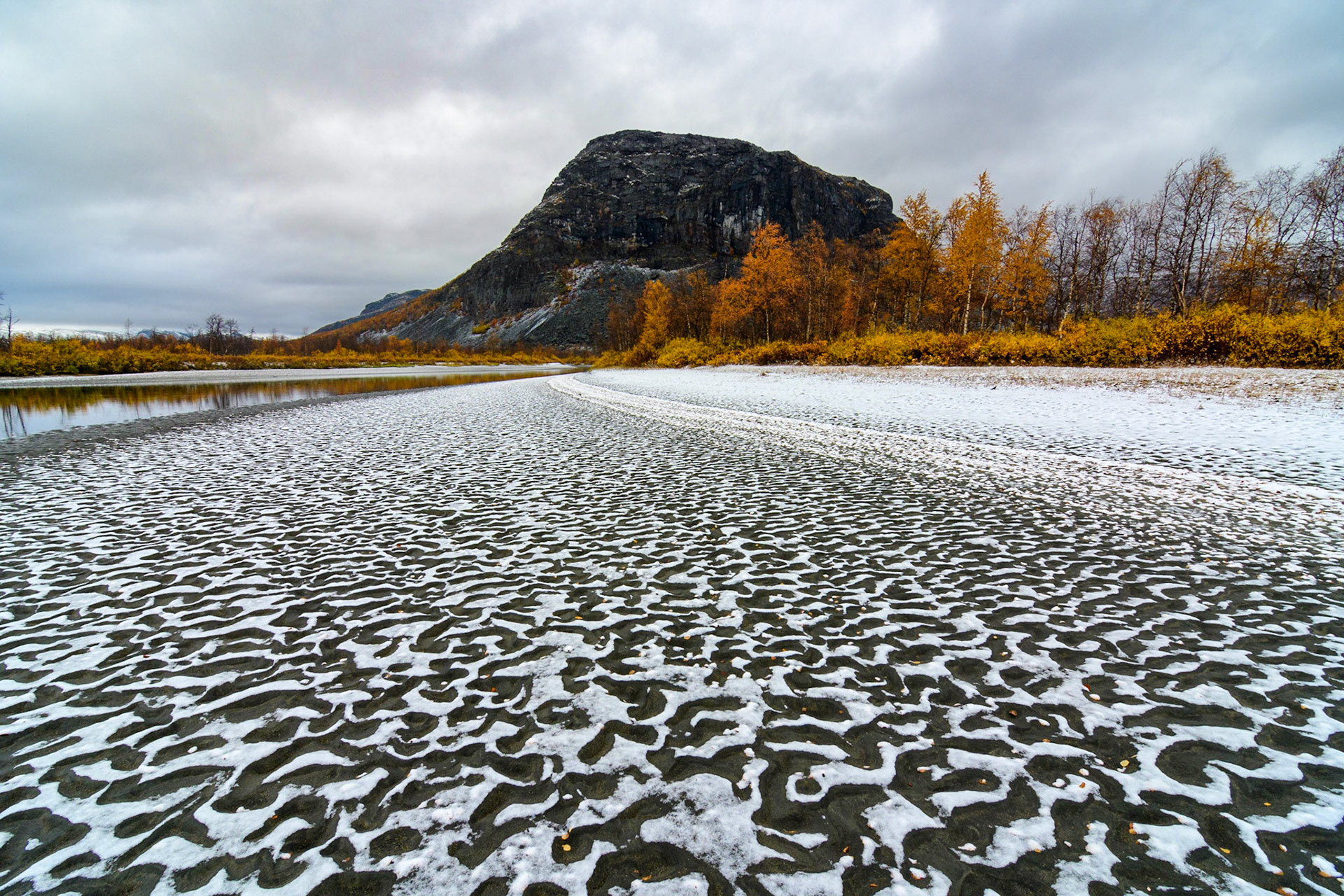 Snow patterns on a river shore of the Rapa river in Sarek National Park, Sweden