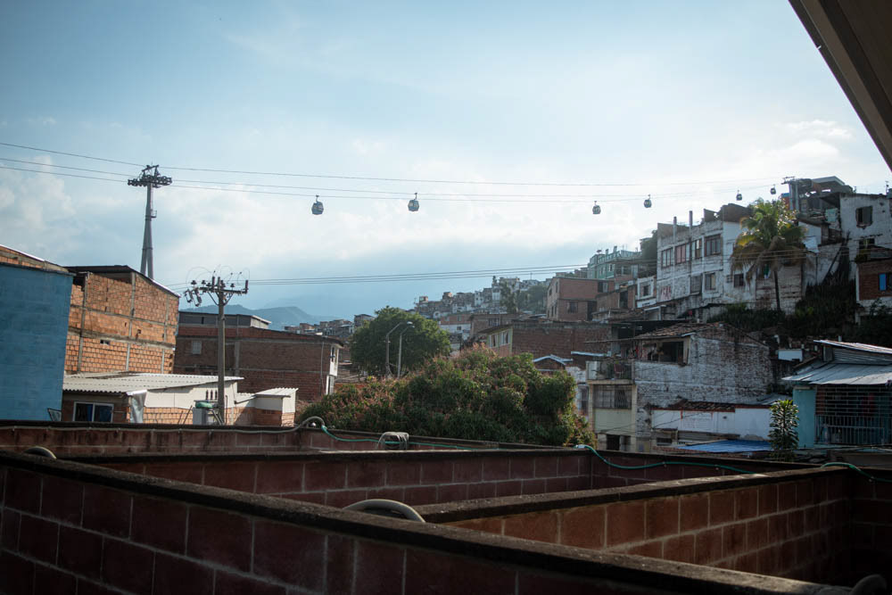 Barrio Siloé en Cali con casas en ladera y teleférico MIO Cable, fotografía documental urbana sobre territorio y desigualdad social.