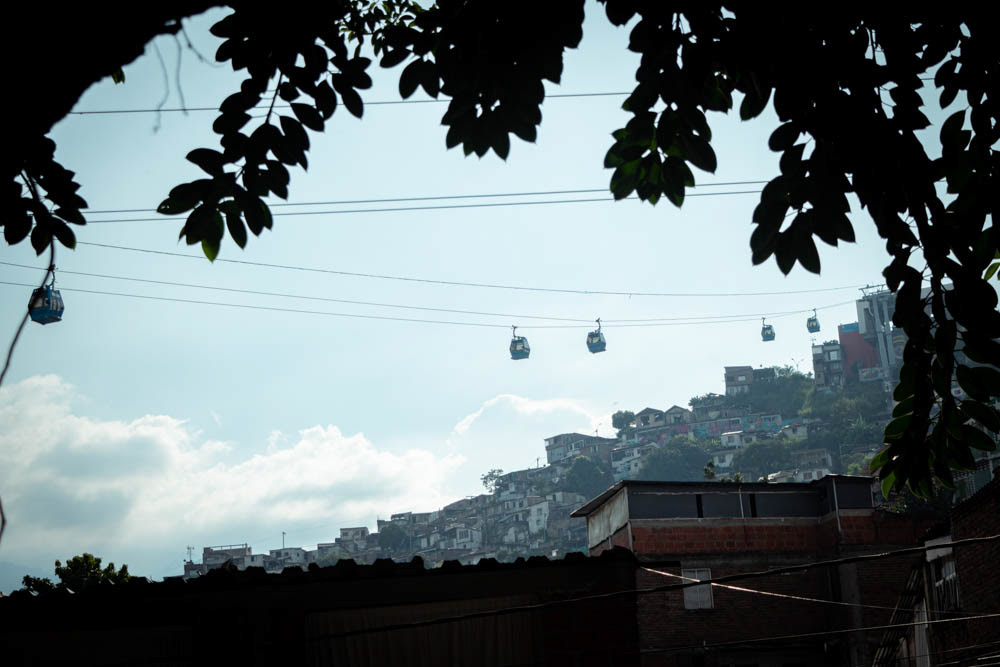 Teleférico MIO Cable sobre barrio Siloé en Cali, viviendas en ladera vistas desde interior urbano, fotografía documental del territorio.