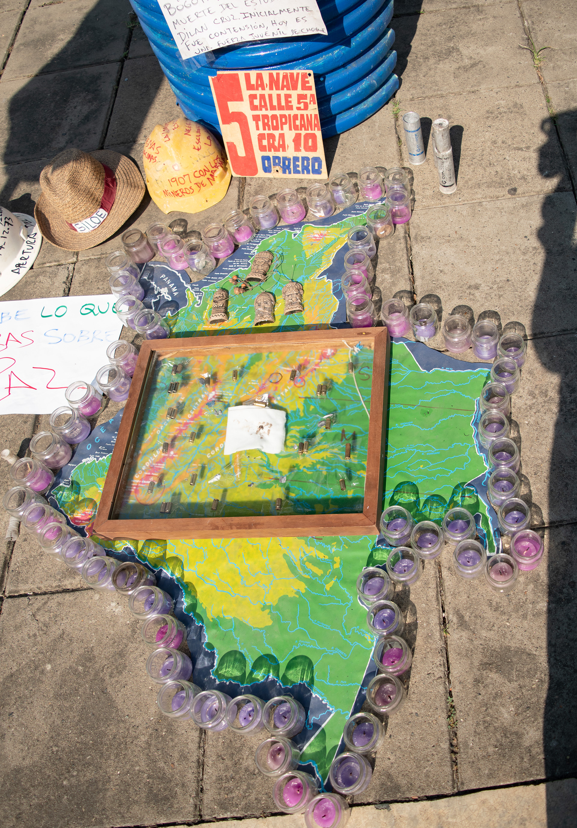 Instalación simbólica del Tribunal Popular en Siloé, Cali, con mapa intervenido y velas en espacio público, fotografía documental social.