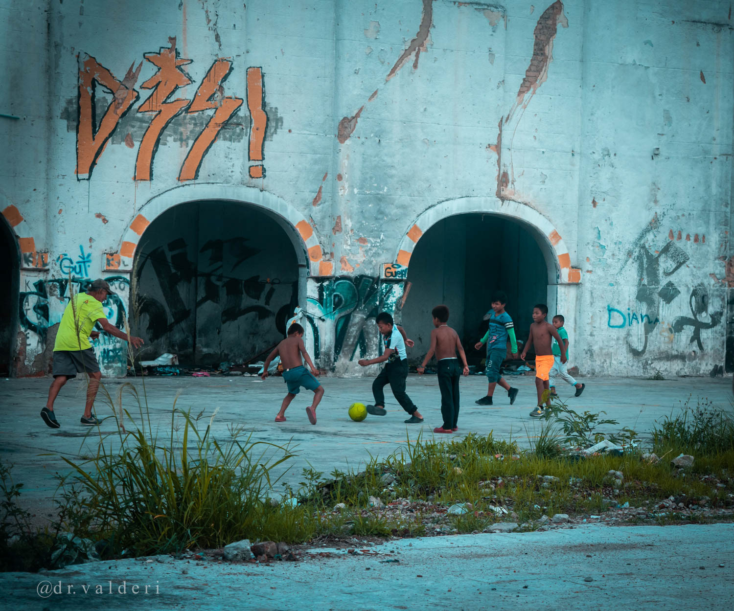 Niños jugando fútbol en espacio urbano de Siloé, Cali, Colombia, reflejando la vida cotidiana, la infancia y las dinámicas sociales del barrio mediante fotografía documental.