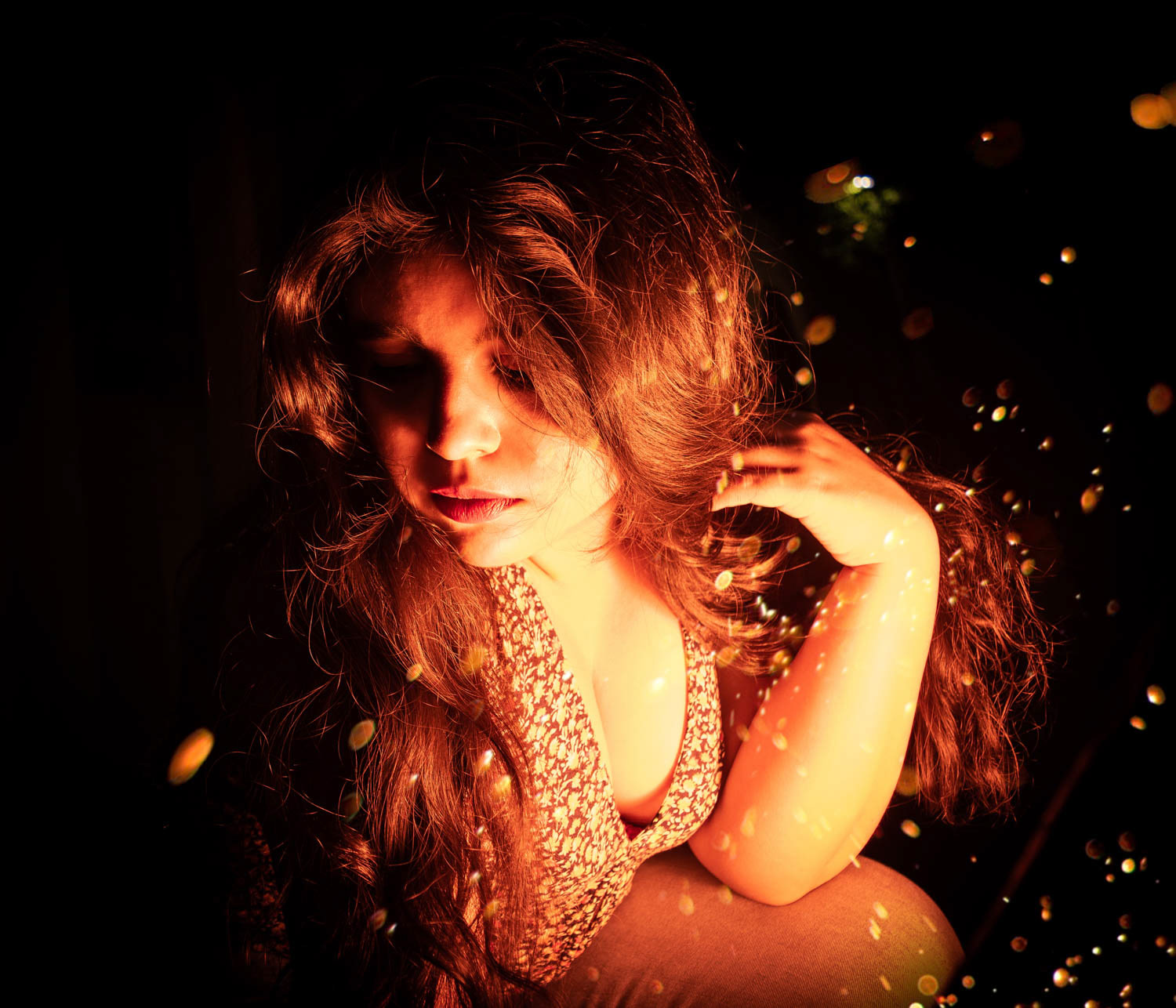 Retrato fotográfico artístico con luz nocturna y partículas.