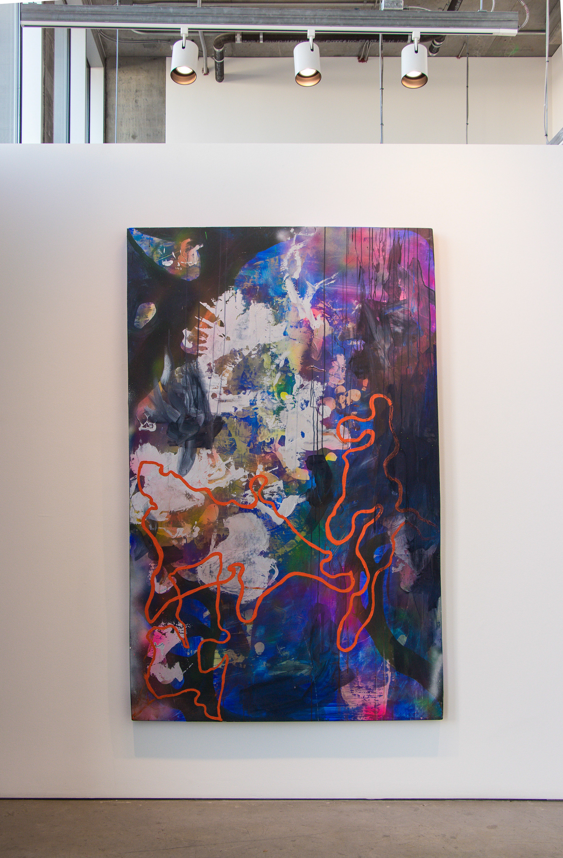 This photograph documents aspects of a painting exhibition called "After Aura." It shows a large, blue abstract painting hanging on a wall with track lighting above it.