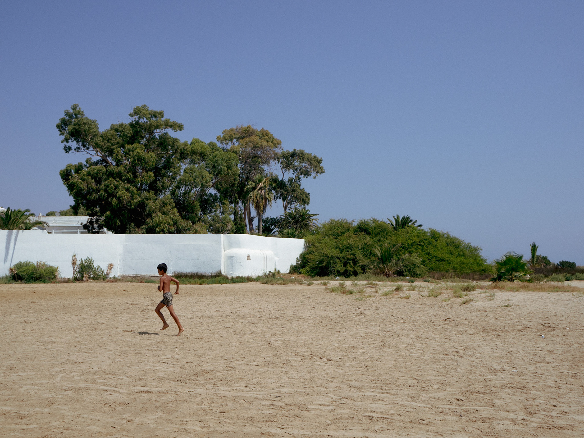 Un jeune garçon courre rejoindre ses amis sur la page à Carthage.