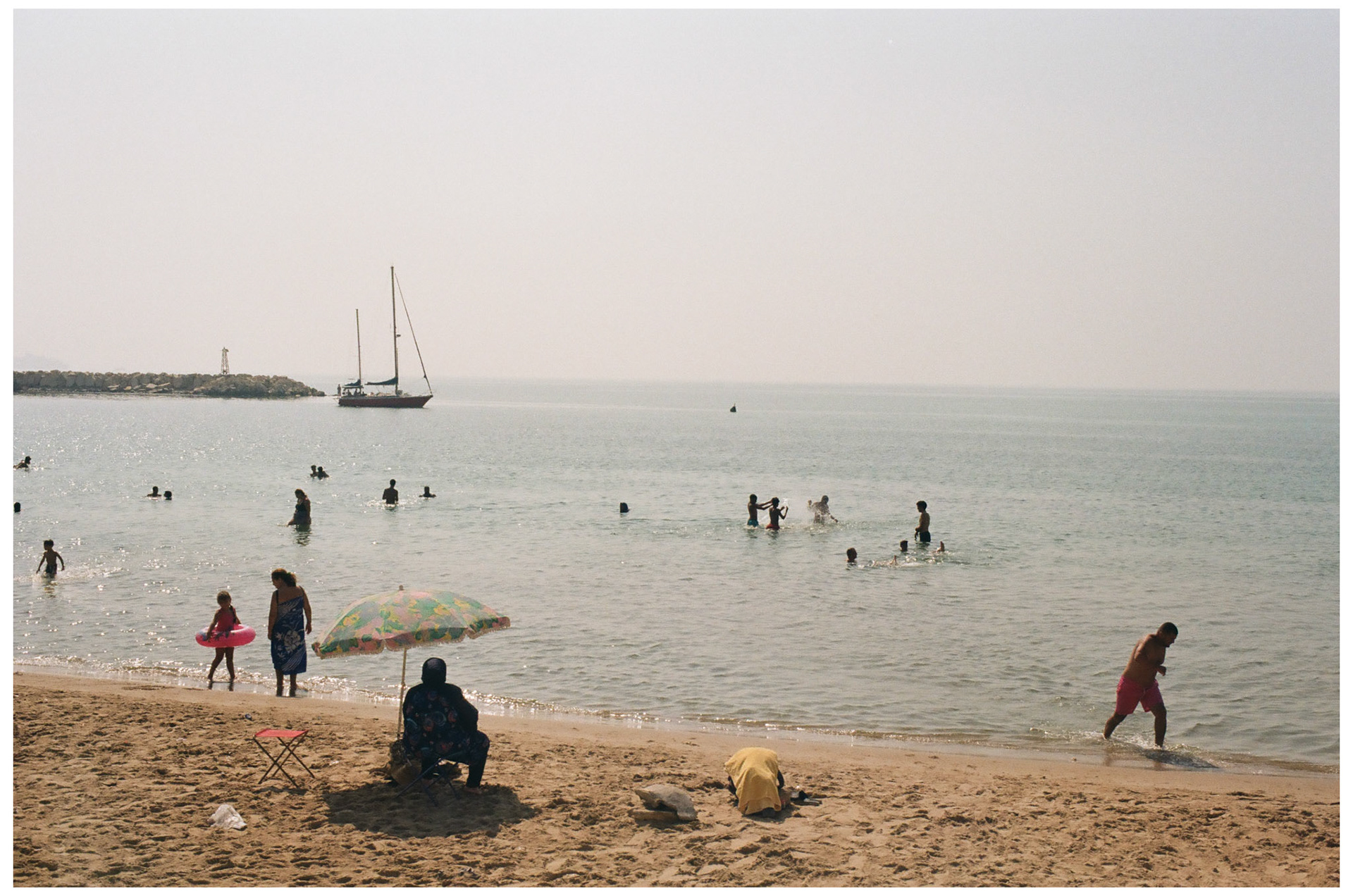 Des résidents profitent de plage à Sidi Bou Saïd près du port, le matin.