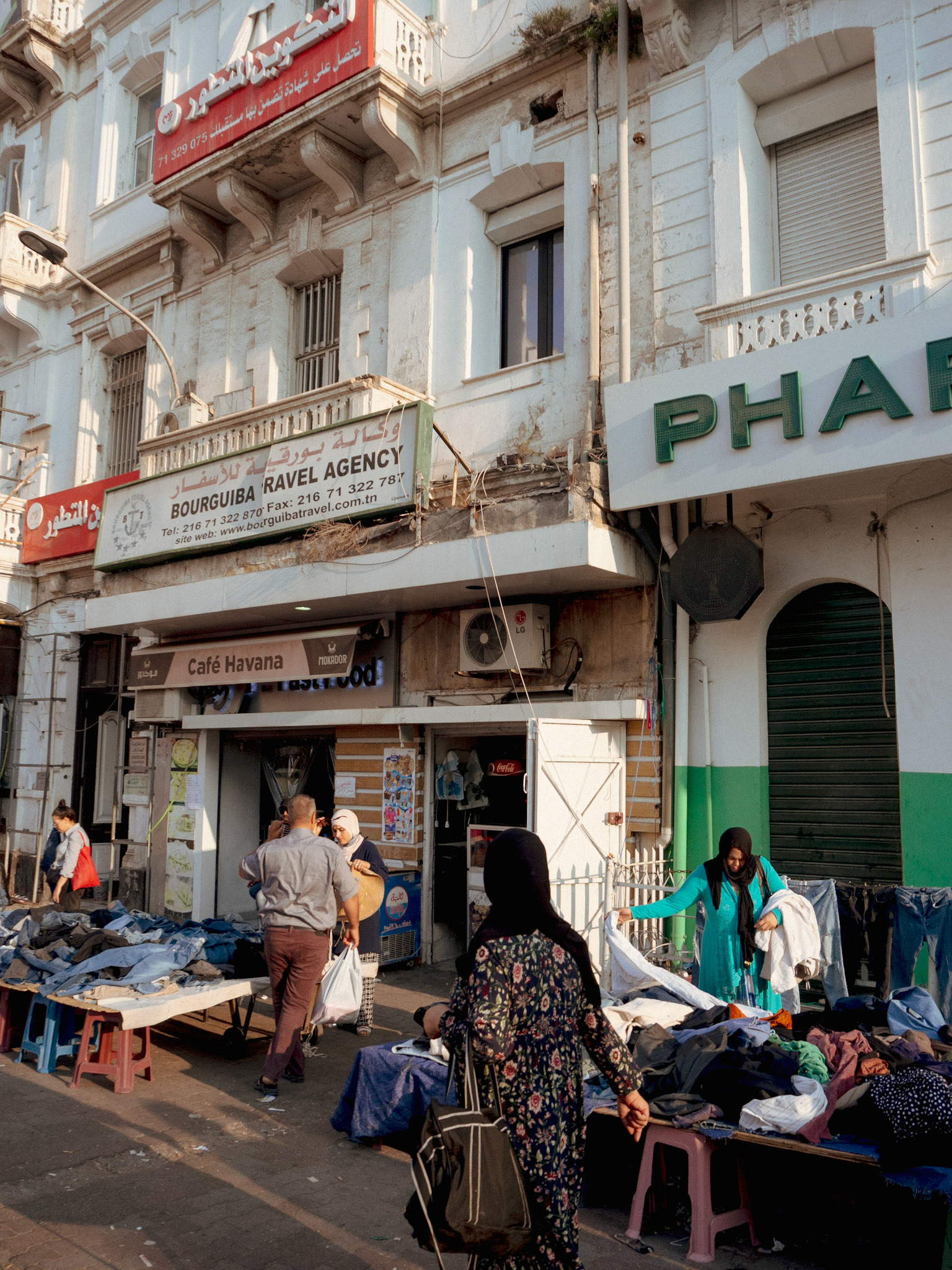 Des commerçants préparent leurs kiosques tôt le matin. Ils n'aiment pas se faire prendre en photo.