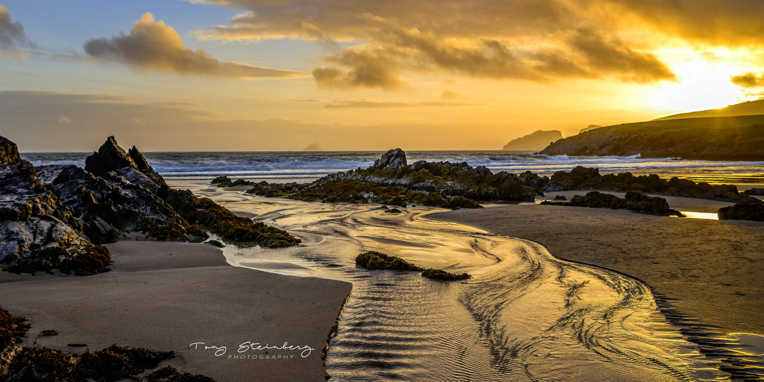 A view of the rocky beach at St Finian's Bay, Ireland, looking out toward the distant Skellig Michael, or Great Skellig Island, famous for thriving gannet and puffin populations, and for an early Christian monastery that is now a UNESCO World Heritage Site.