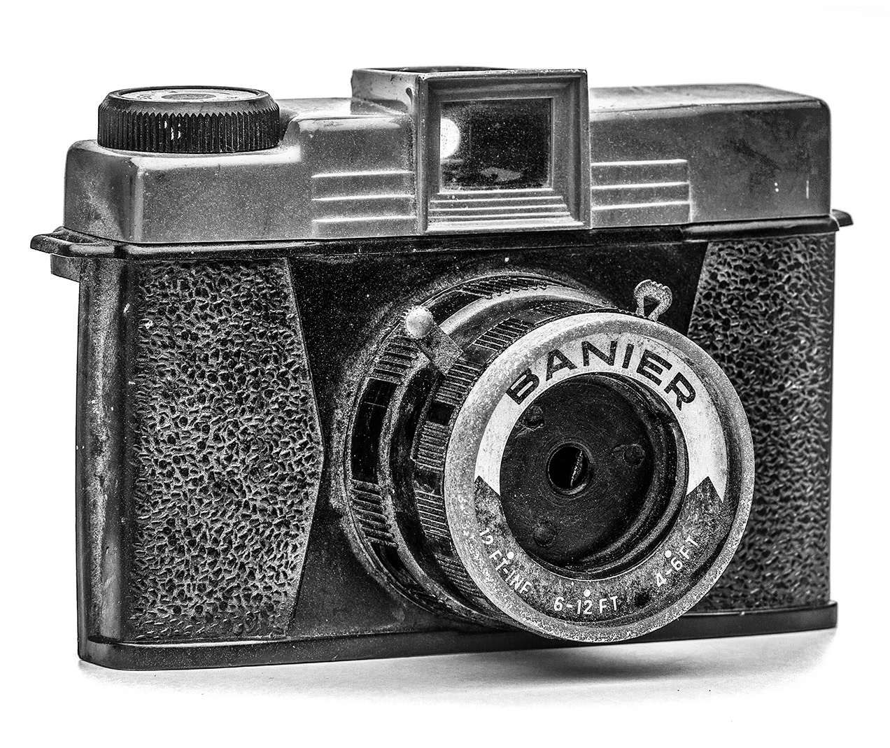 black and white photo of old grungy toy camera on white background