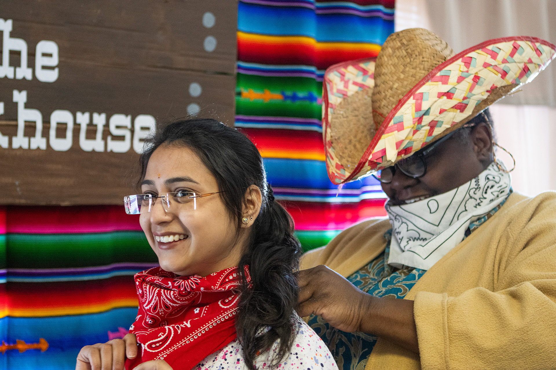 Marschelle McCoy helps Devika Jaiswal, a biological sciences graduate student, put on her handkerchief for the United Pentecostal Tabernacle church’s western themed lunch event on April 6