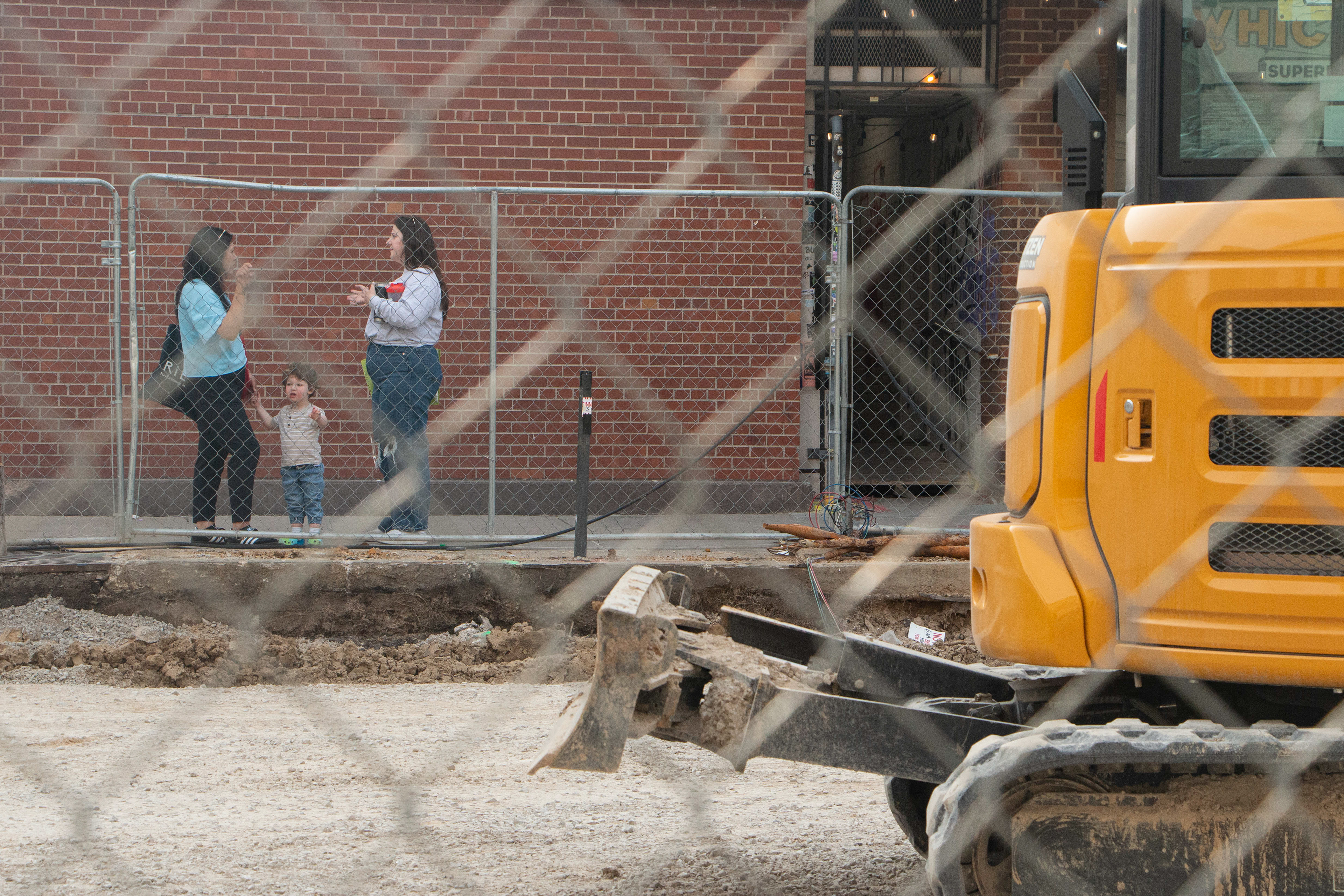 Kid looks at the construction site while mom talks on April, 10, 2024, Iowa City, IA