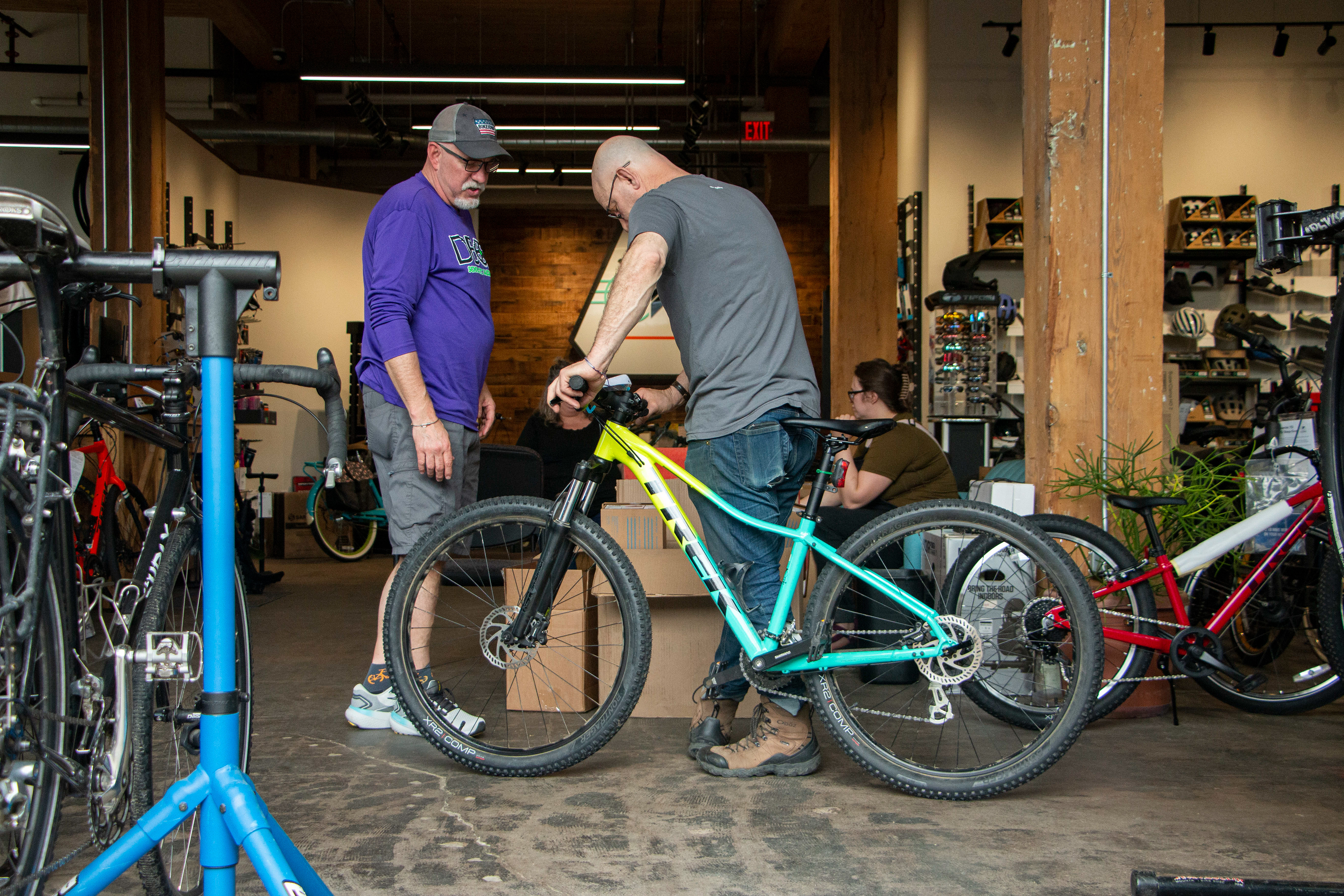 Bicycle World in Dubuque, IA on April 27, 2024. David Hartig, the owner of the shop, helps Kalyn's dad with a bike.