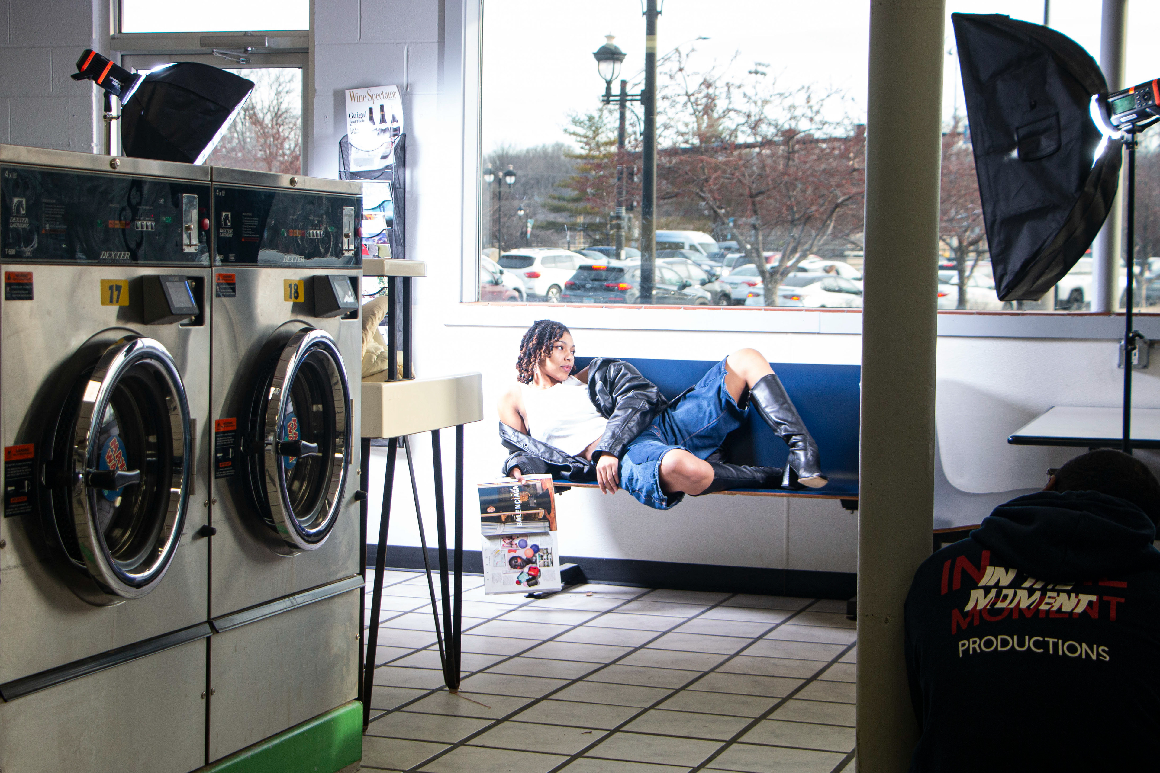 Jahn Hawkings does a photoshoot at Laundromania in Coralville on Wednesay, Feb. 14, 2024. Jahn's photographer, Fazon Stanton, takes pictures with his studio lights.