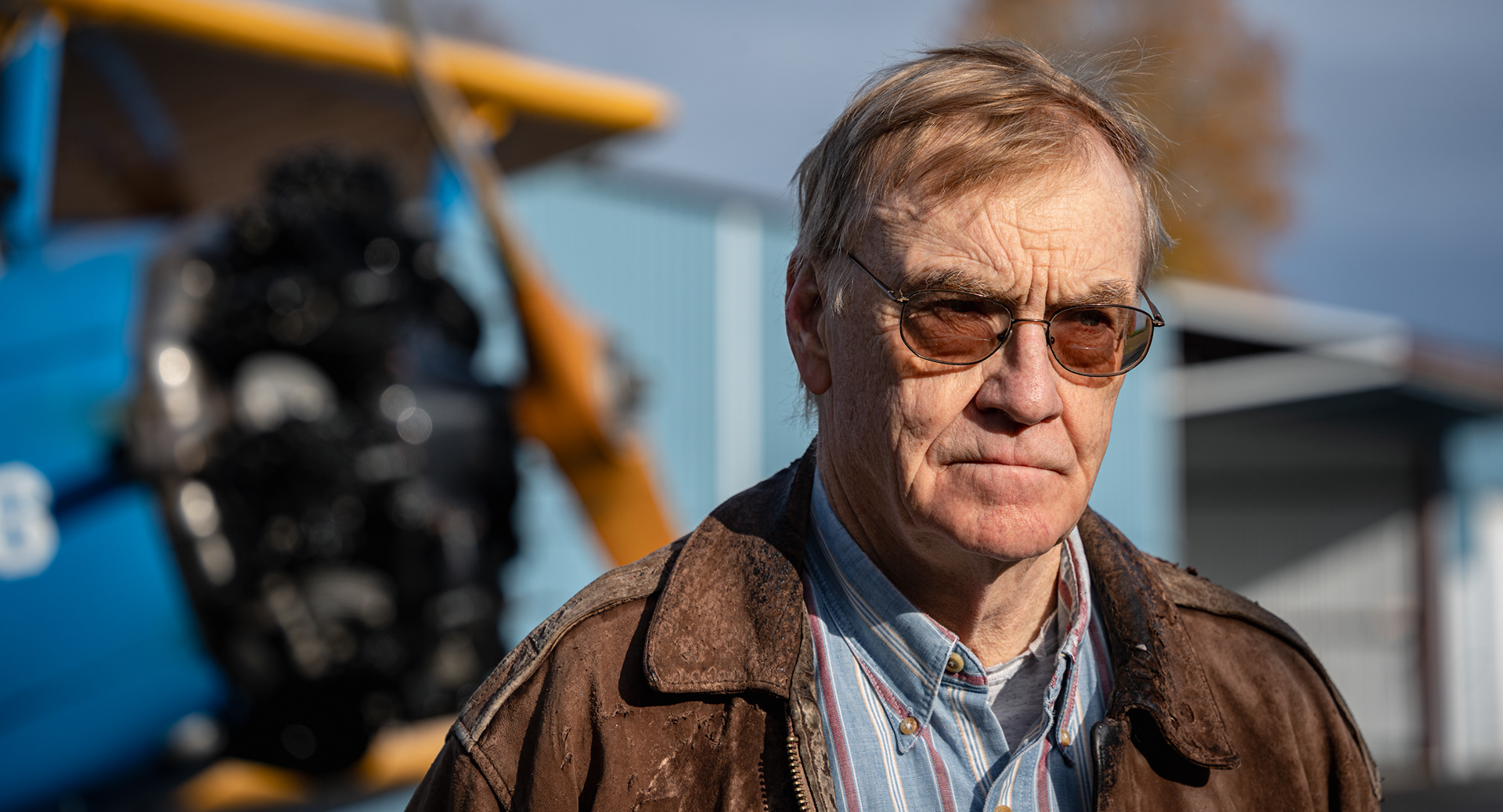Bob Williams, semi-retired trial attorney and avid aviator, stands in front of his Steerman at the Skaneateles Aerodrome in New York