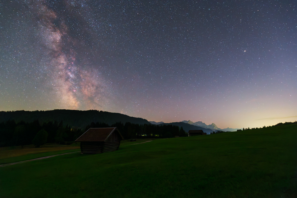 Central bulge of Milky Way in astronomical twilight over a hut near Geroldsee, Bavaria.