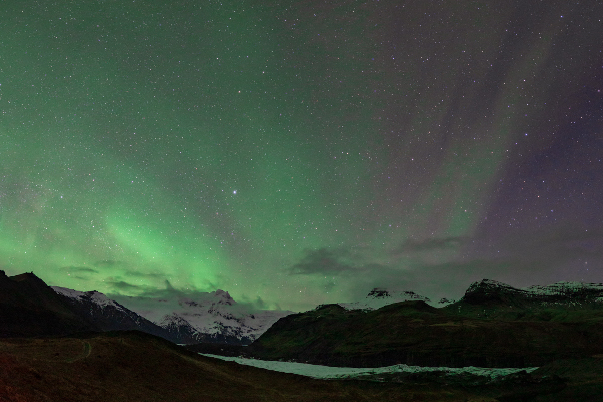 Panoramic view of green aurora over Skaftafell glacier, southern Iceland.