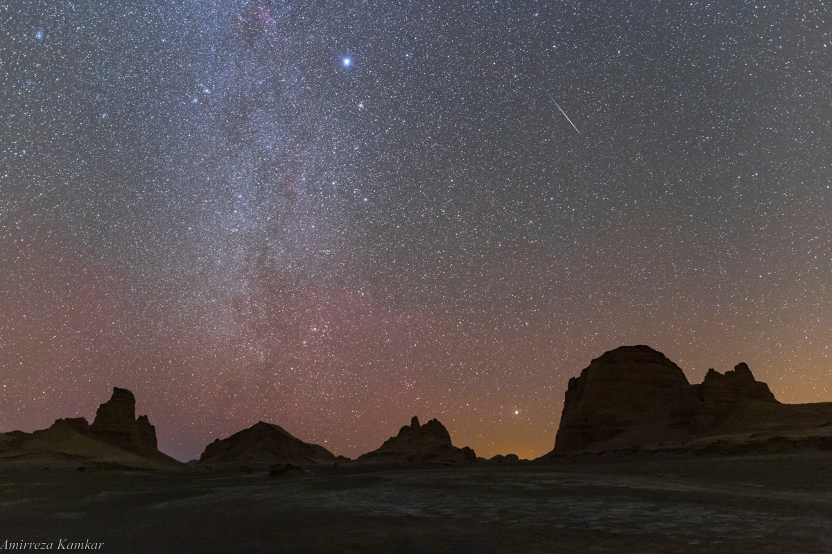 A faint Geminid meteor and Canis Major constellation in the dark sky of Lut Desert, Iran. Canopus, the second brightest star in the night sky, is viisble just above the horizon.
