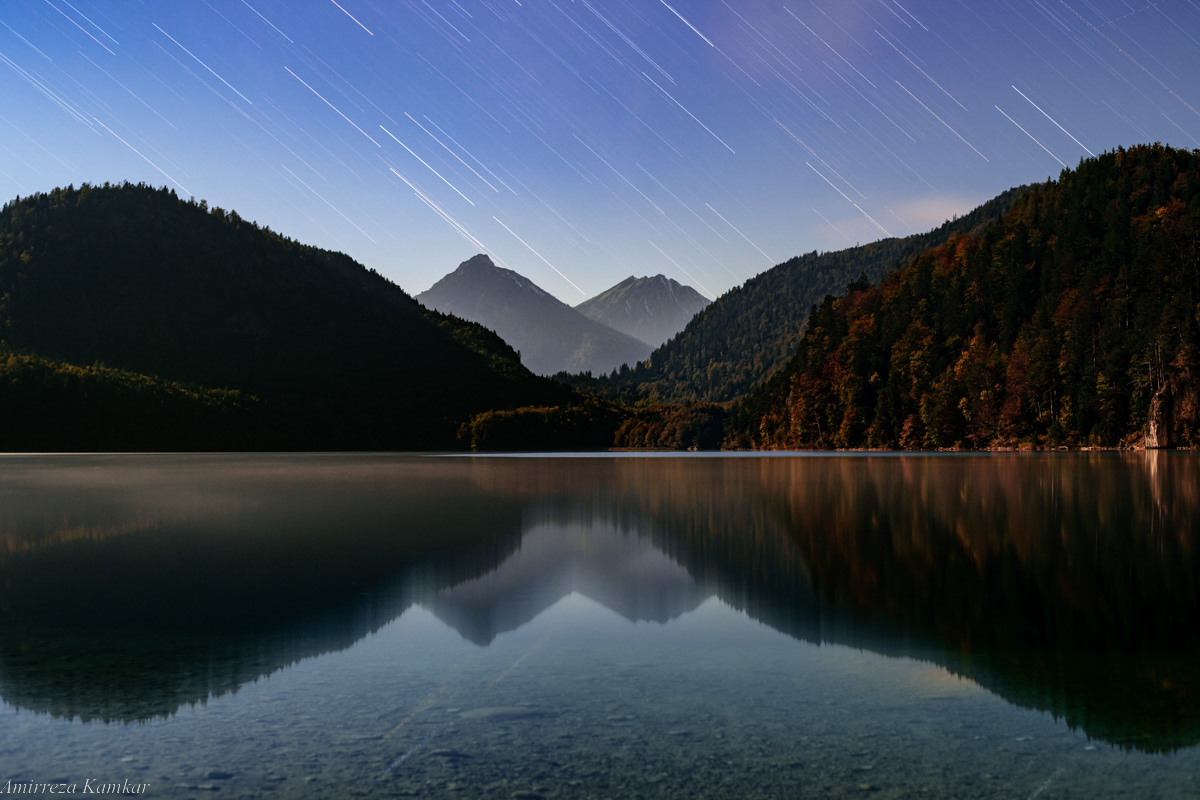 Star trails over Lake Alpsee in Bavaria, Germany.