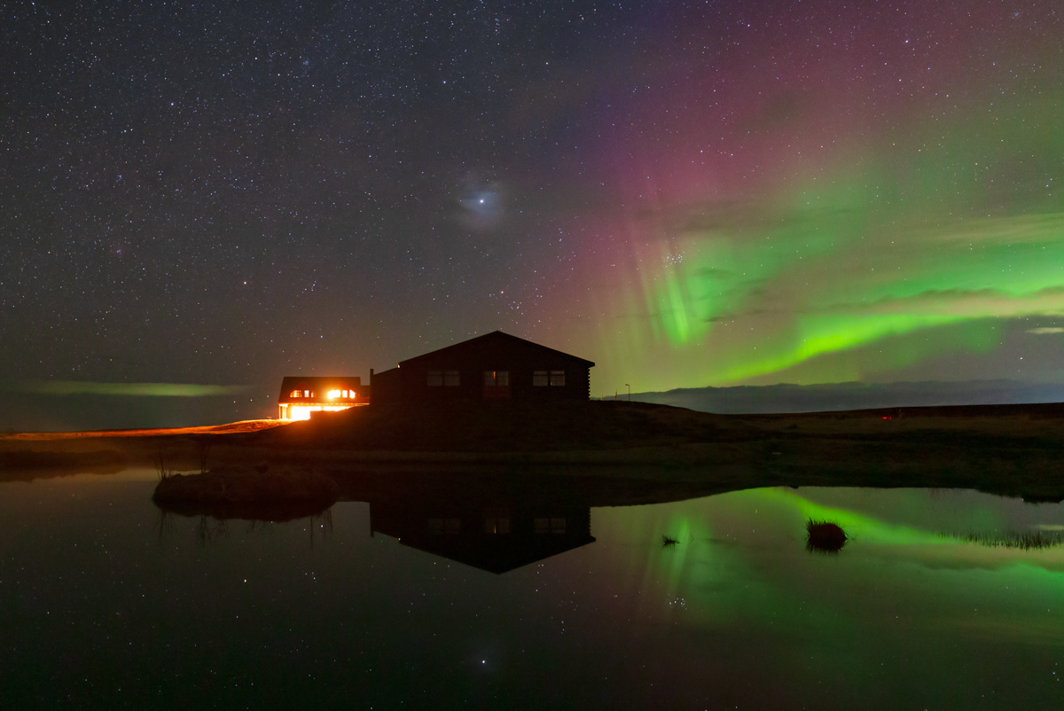 Northern light and the setting Winter constellations and planet Jupiter over a small pond. Captured on March 2025 in Iceland. Note for the corona around the Jupiter, caused by thin clouds.