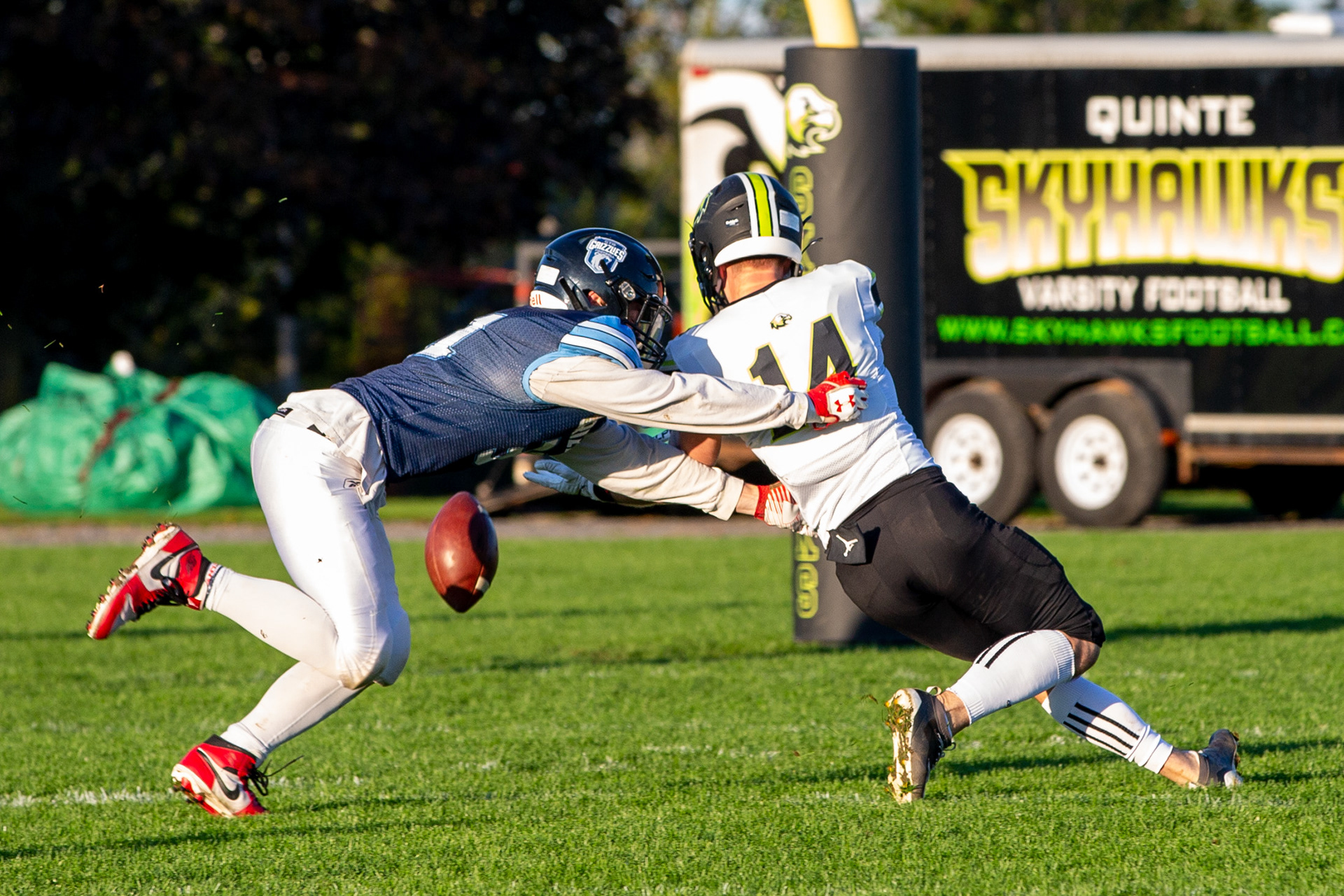London, Ont.—Carter Stephens, quarterback of the Quinte Skyhawks, clutches the ball during a game against the London Beefeaters at City Wide Sports Park as Mathieu Labelle and Jarett Hicks (right) tackle him. The last game of their regular season for the Canadian Junior Football League, the Skyhawks lost 0-49. Photo by Kayla Isomura