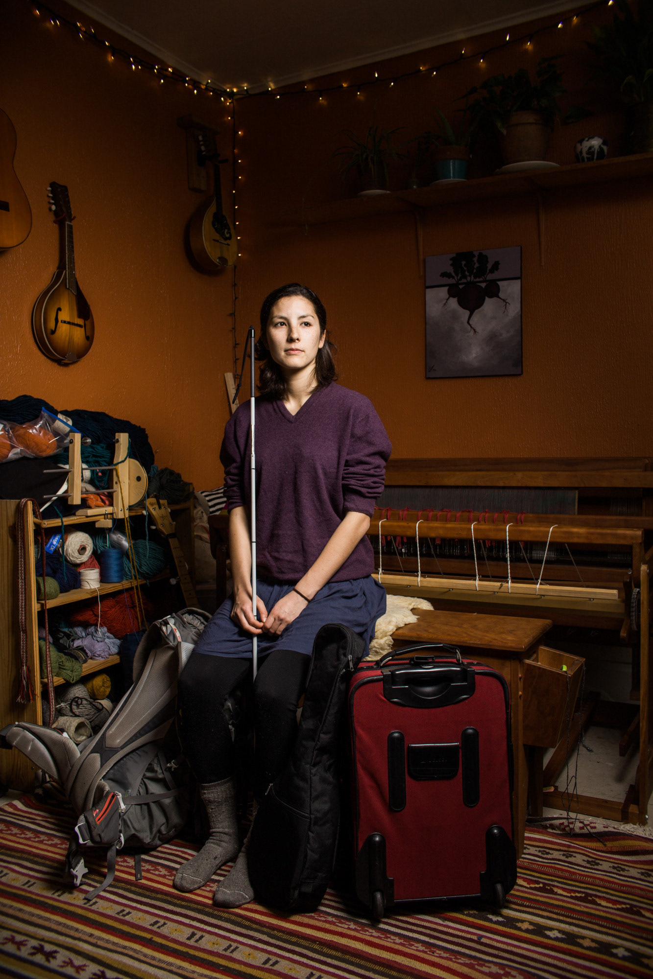 Seattle, WA—Naomi Harrington, 29, sits in her Wallingford home with luggage that includes an ukulele made by her dad, cookware and a notebook. Harrington is a fourth generation Japanese Canadian living in the US for work. Photo by Kayla Isomura, as created for The Suitcase Project