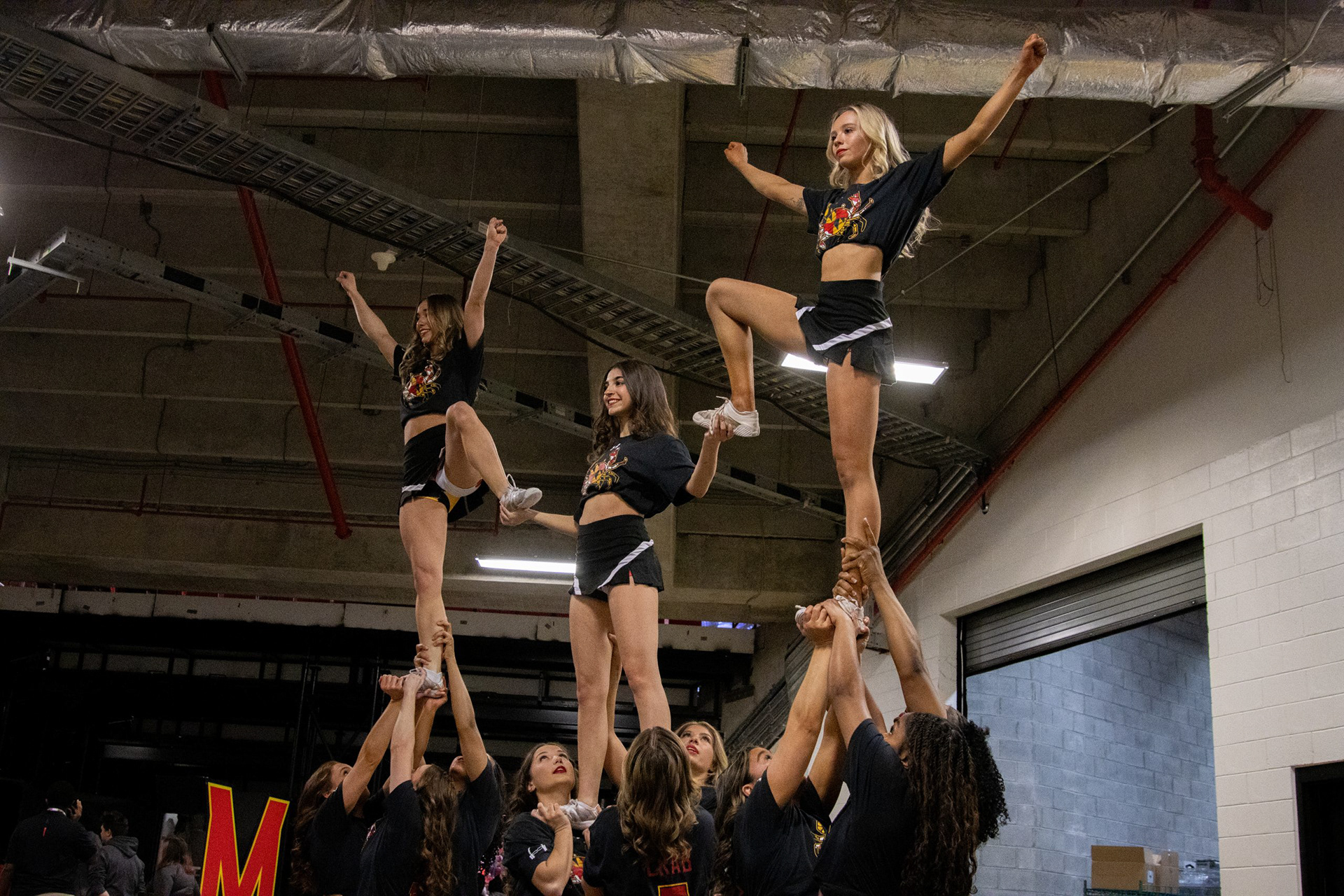 Maryland cheerleaders warm up a stunt prior to a basketball game.