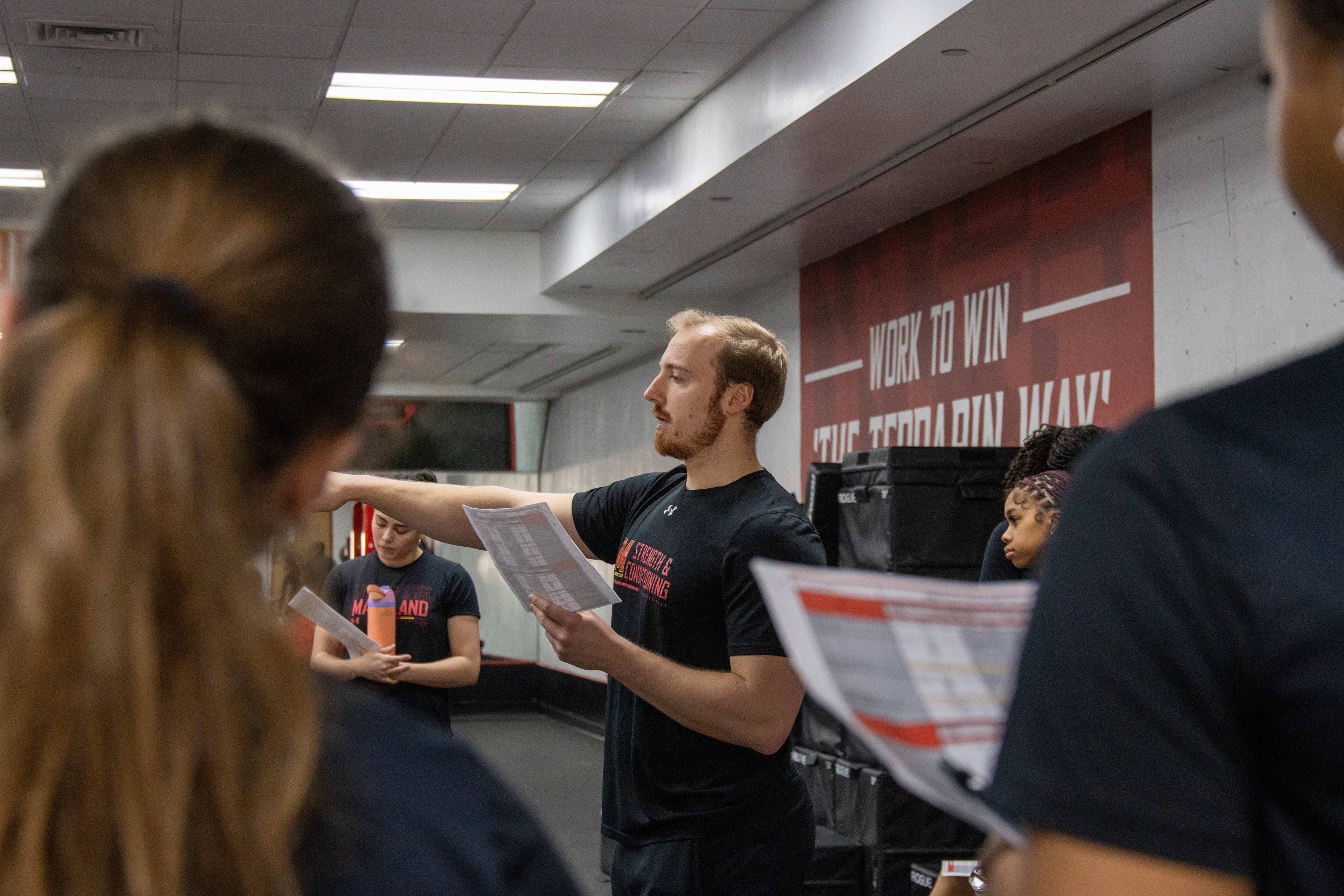 Braedon Lambros, Maryland cheer’s strength coach, briefs cheerleaders on their workouts on March 4, 2025.