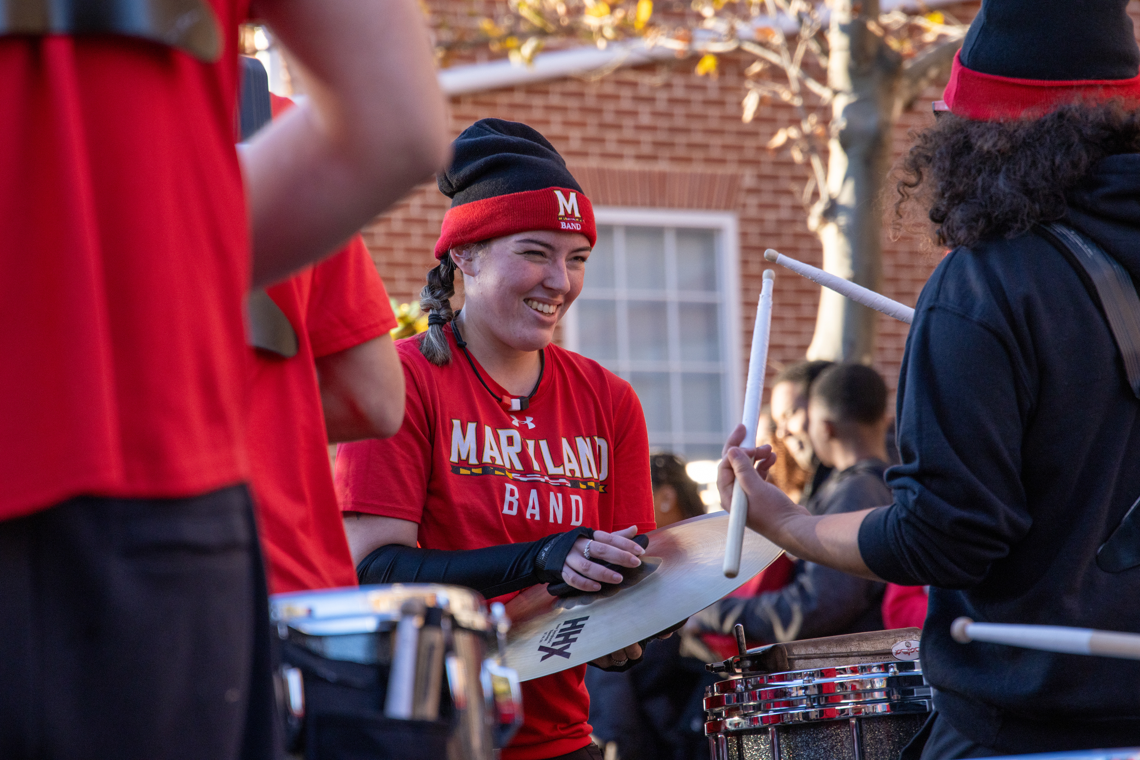 Angelina Mussini, squad leader of the cymbal section, holds their cymbals for a fellow drumline member at the Terp Alley performance on Nov. 16, 2024.