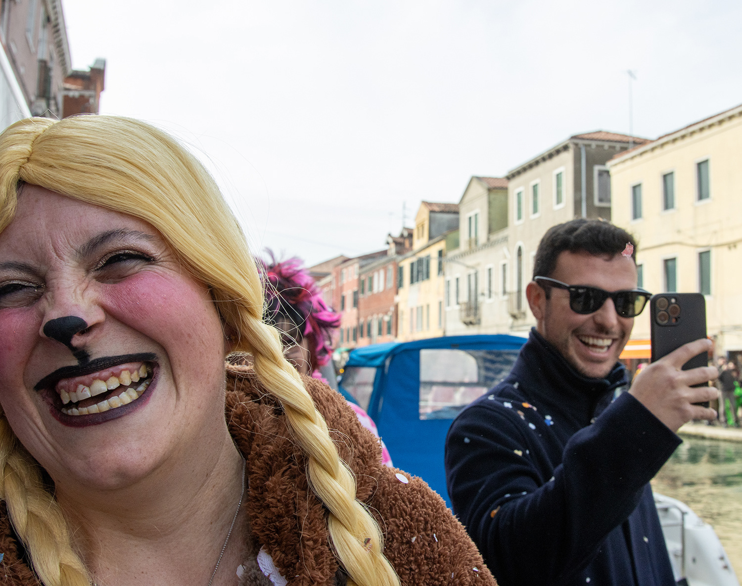 A woman laughs after tossing confetti at pedestrians during Murano's Carnevale parade on Feb. 8, 2026 in Murano, Italy. 