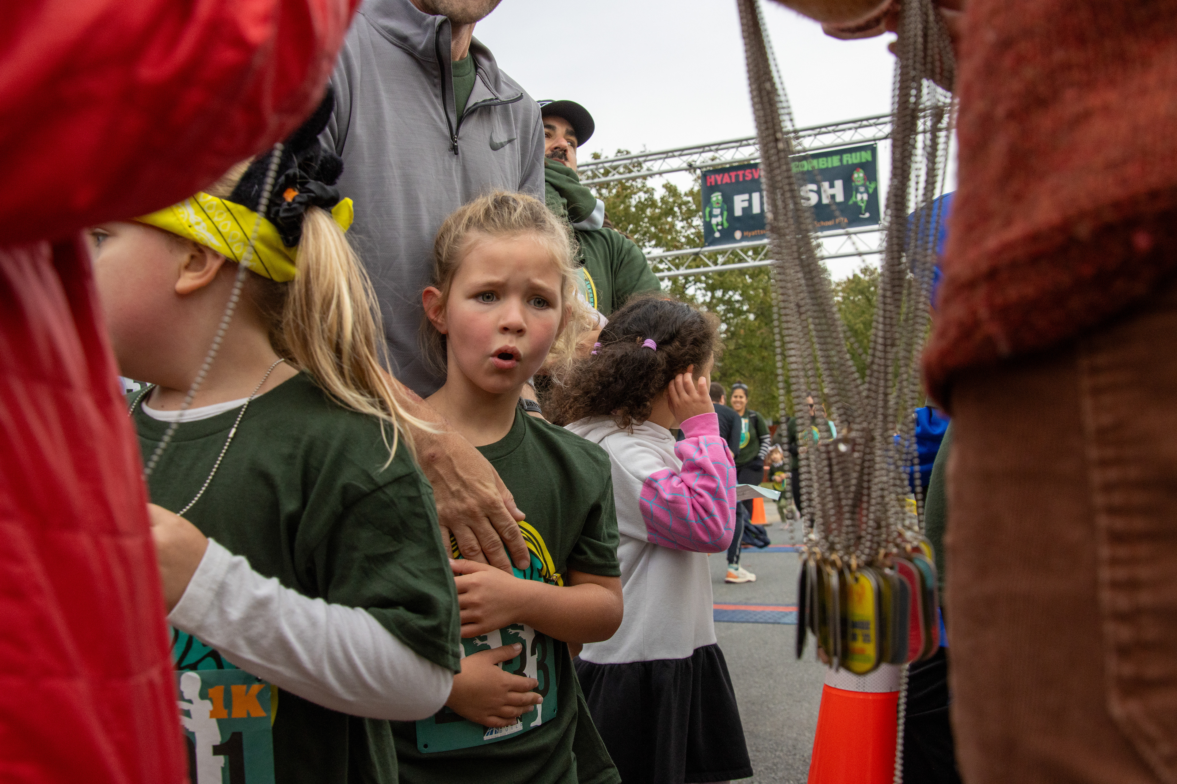 A girl looks at medals after running in the Hyattsville Elementary School's Zombie Run 1k race on Oct. 18, 2025.