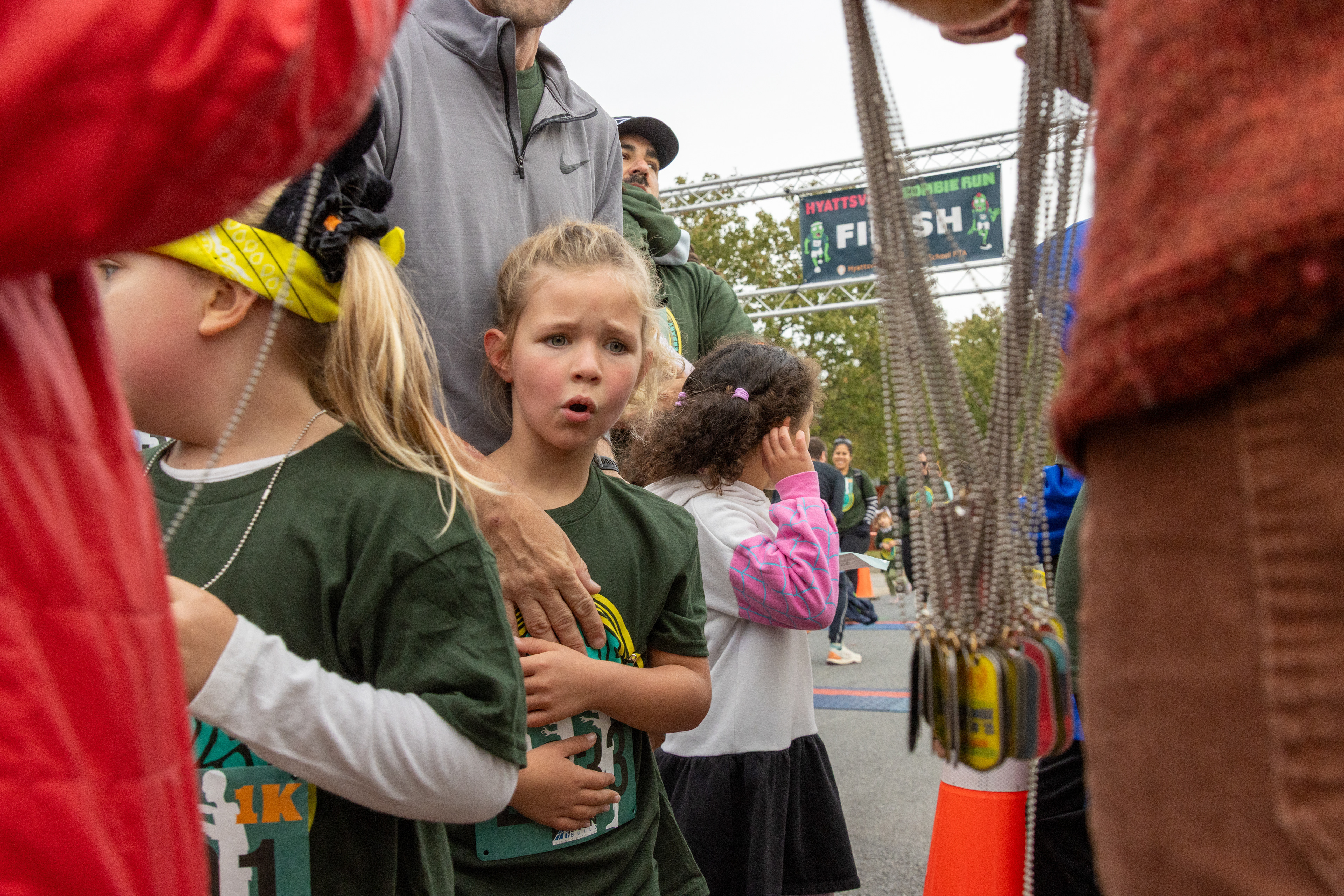 A girl looks at medals after running in the Hyattsville Elementary School's Zombie Run 1k race on October 18, 2025.