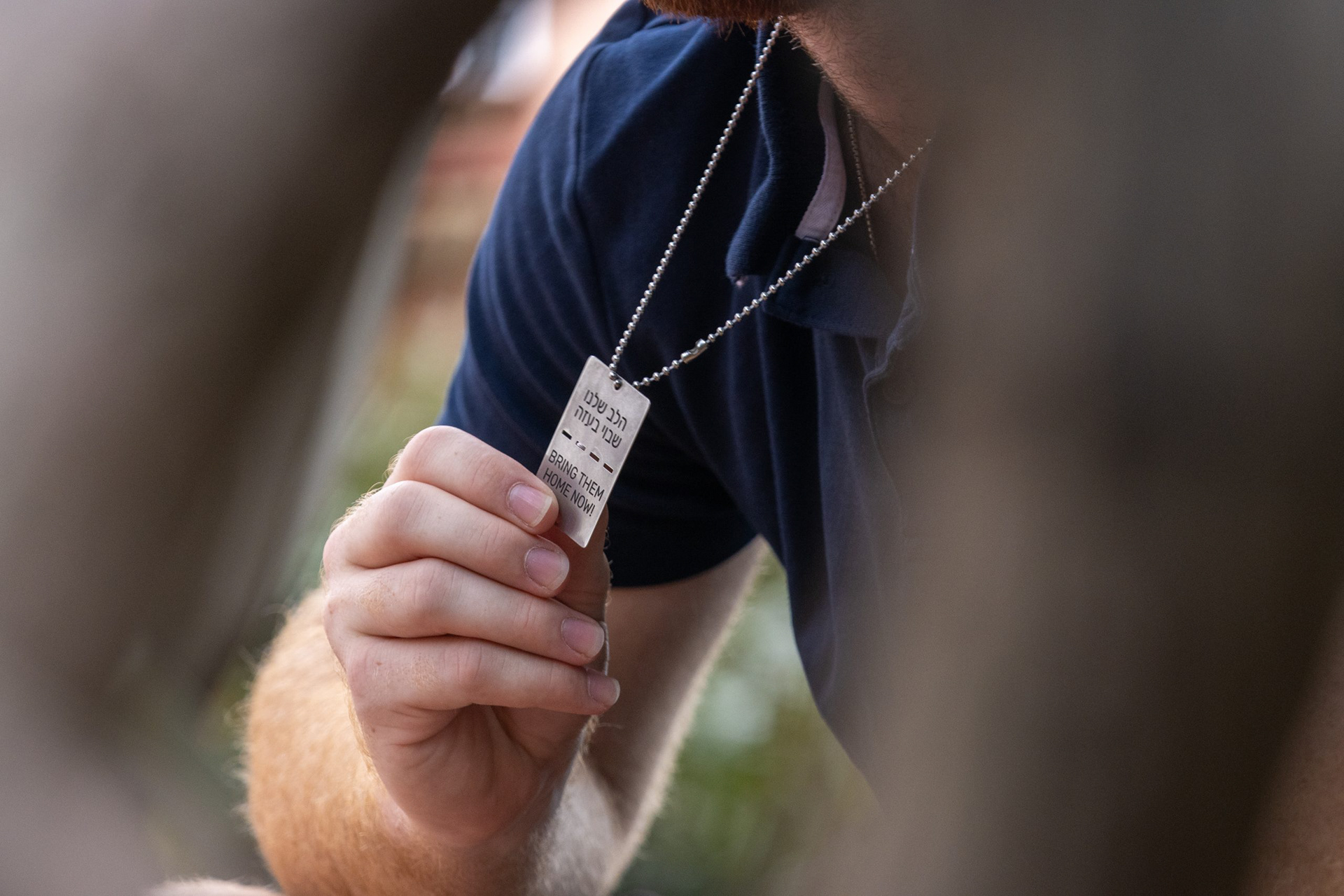 Stone Schwartz, a junior mechanical engineering major, holds a necklace engraved with “Bring them home now!” in reference to the Israeli hostages that remain in Gaza.